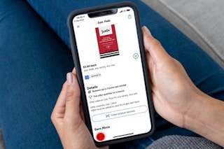 woman holding phone with ibotta app showing mooney back for buying just a period tampons