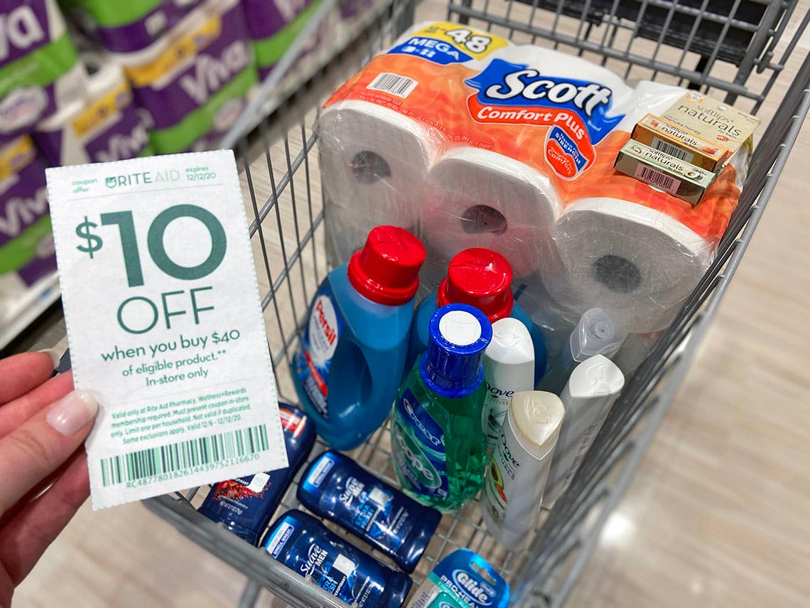 someone holding coupon next to cart full of products