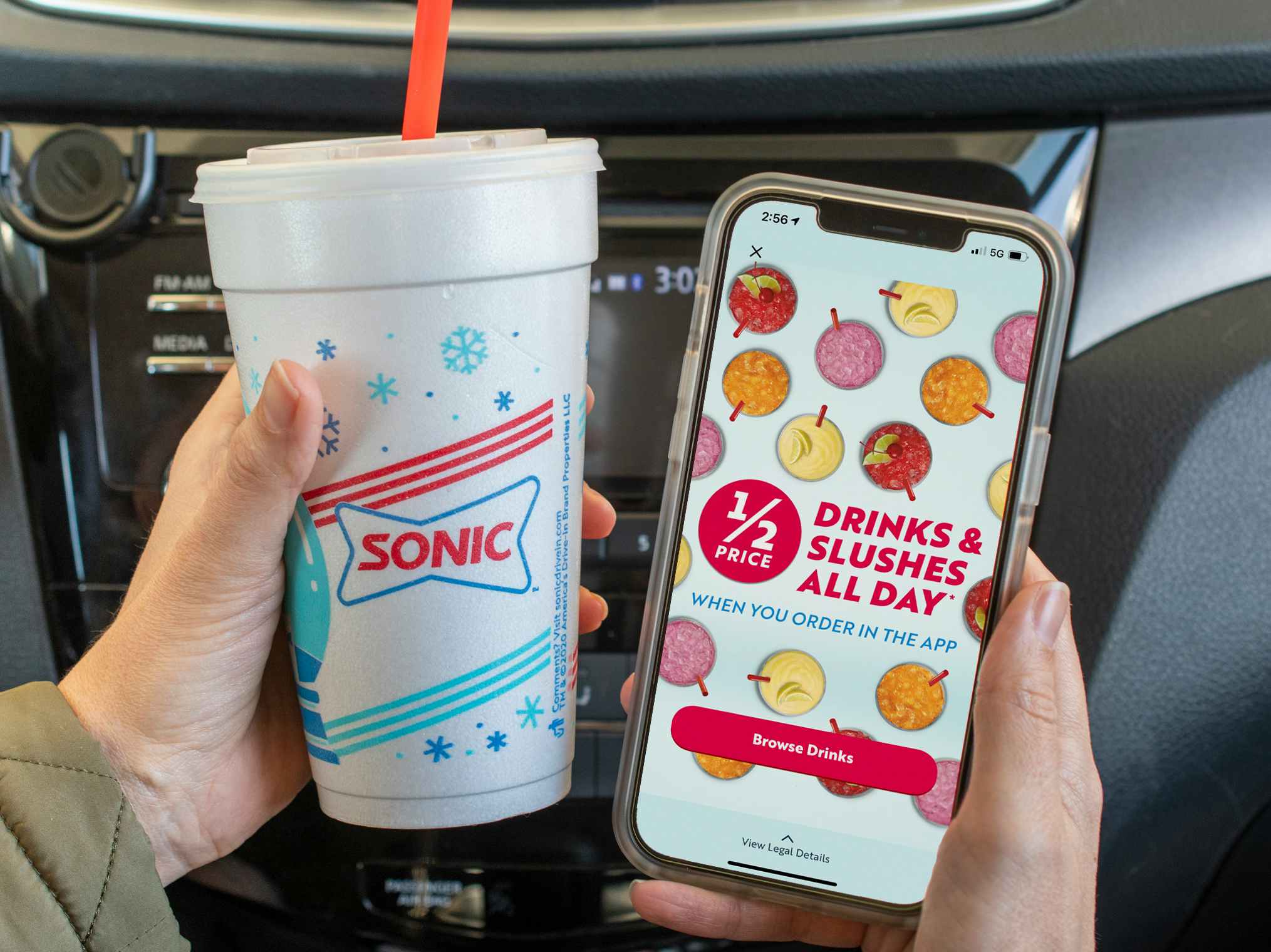 1/2 drinks and slushes all day" ad inside the Sonic app on a cell phone, next to a sonic cup.