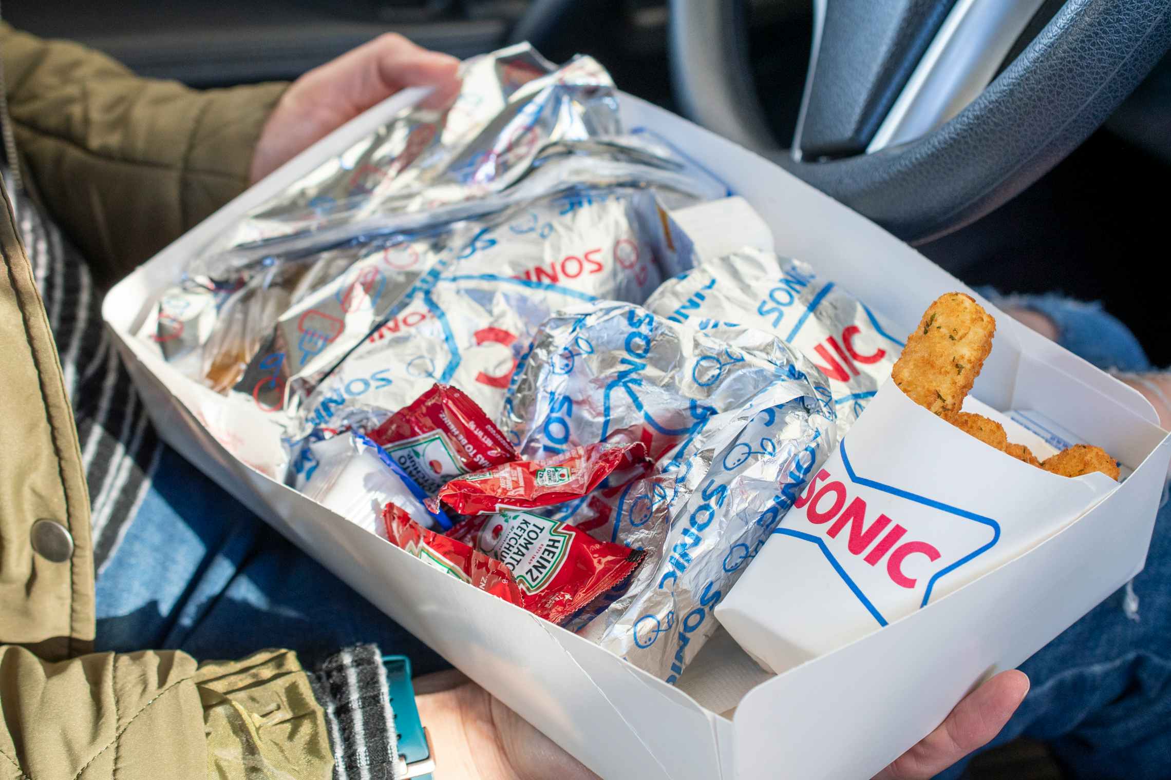 A box full of fast food items, displaying the sonic logo on the packaging.