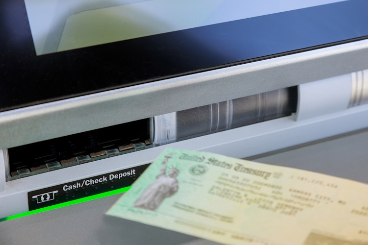 someone sticking a check in a bank