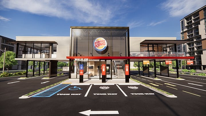 A Burger King storefront showing mobile order pickup parking spaces, and three drive-thru lanes.