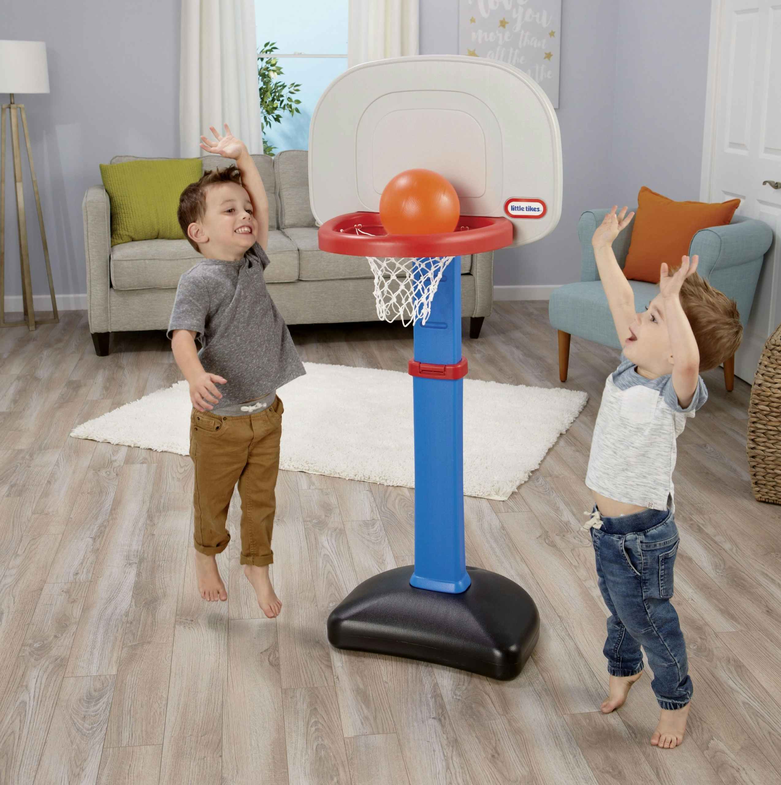 Two kids playing with the Little Tikes basketball hoop.
