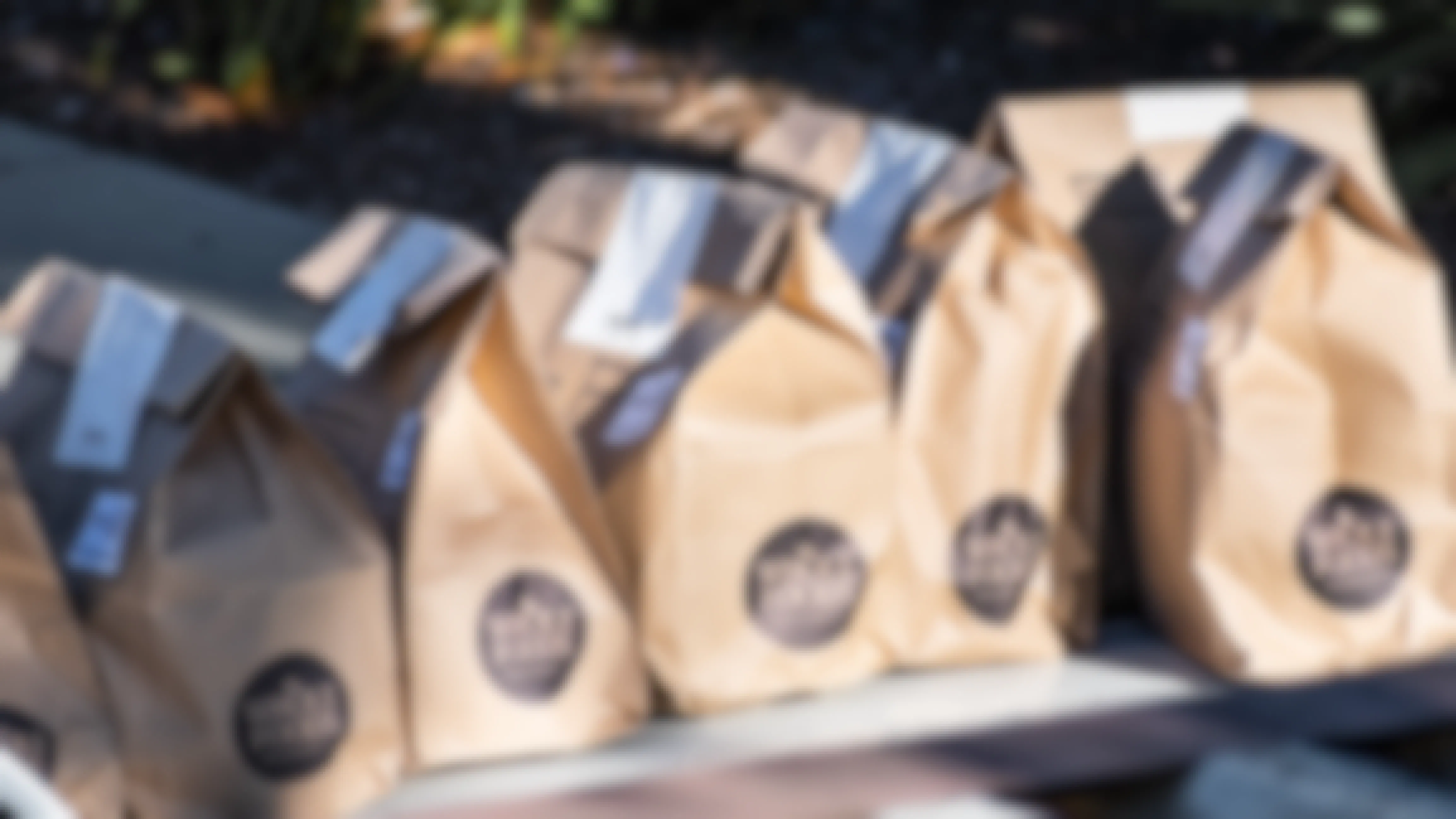 Brown paper bags with the Whole Foods logo marked on the side, lined up in a row.