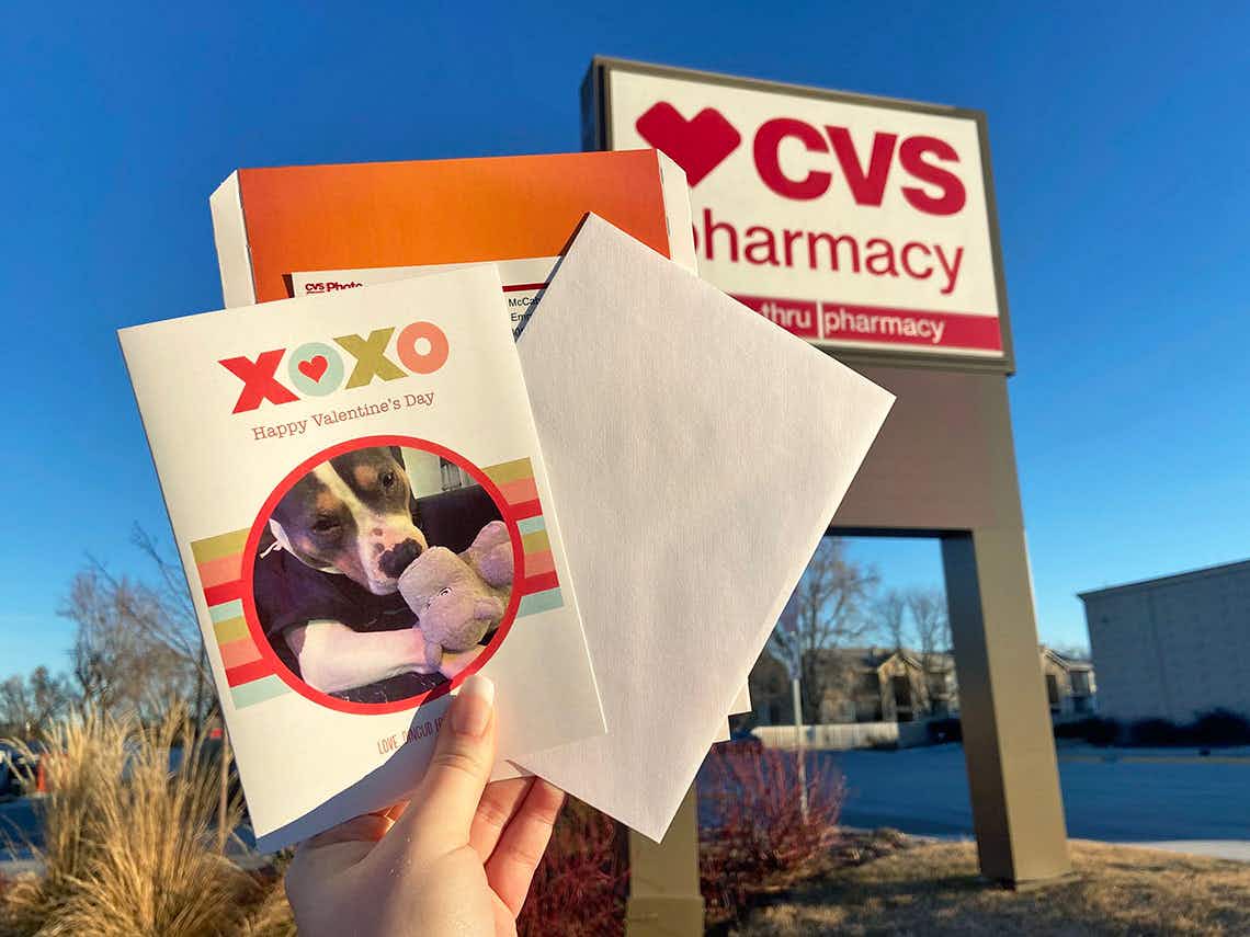 a person holding up a card printed from CVS