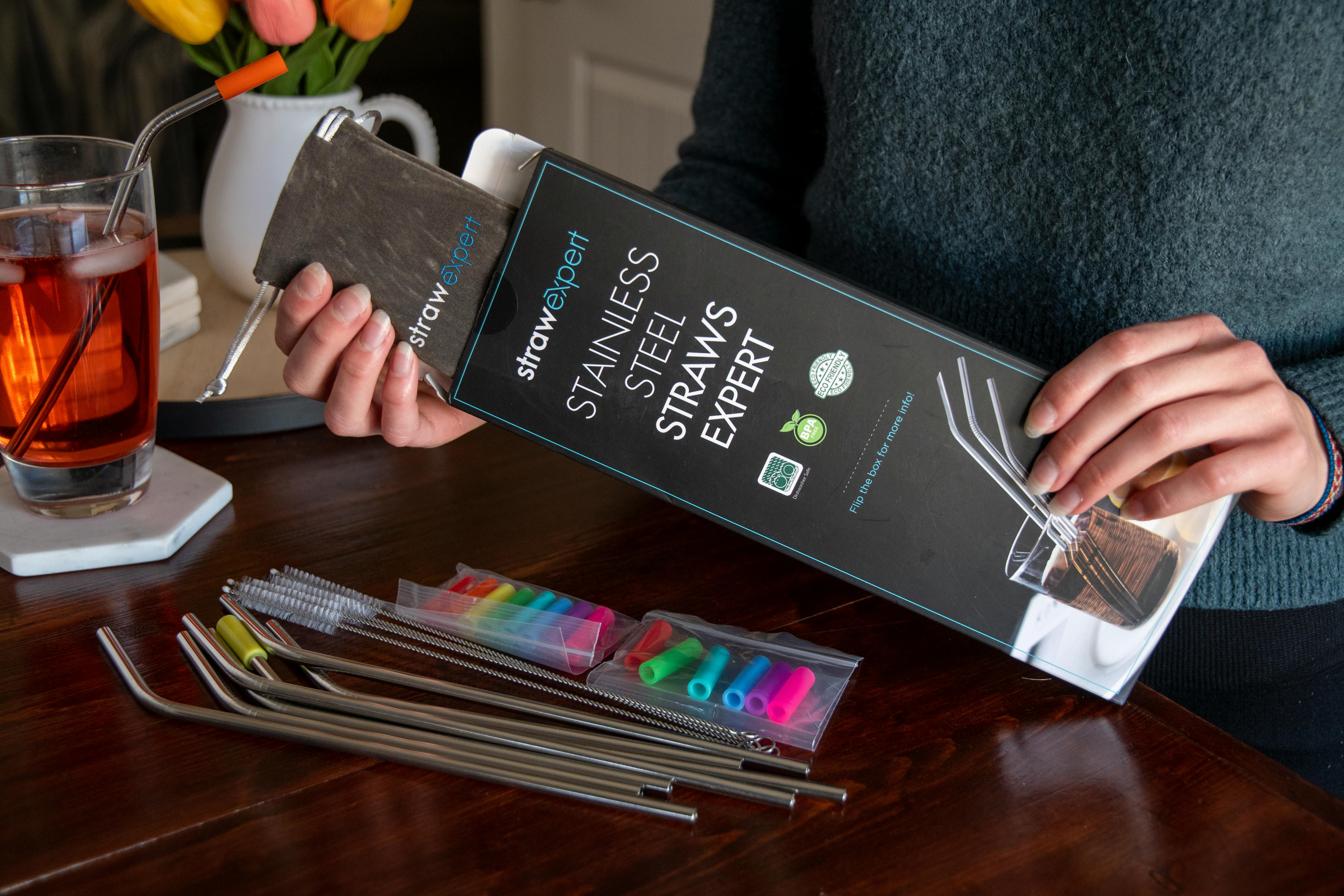 A person pulling stainless steel straws from a package.
