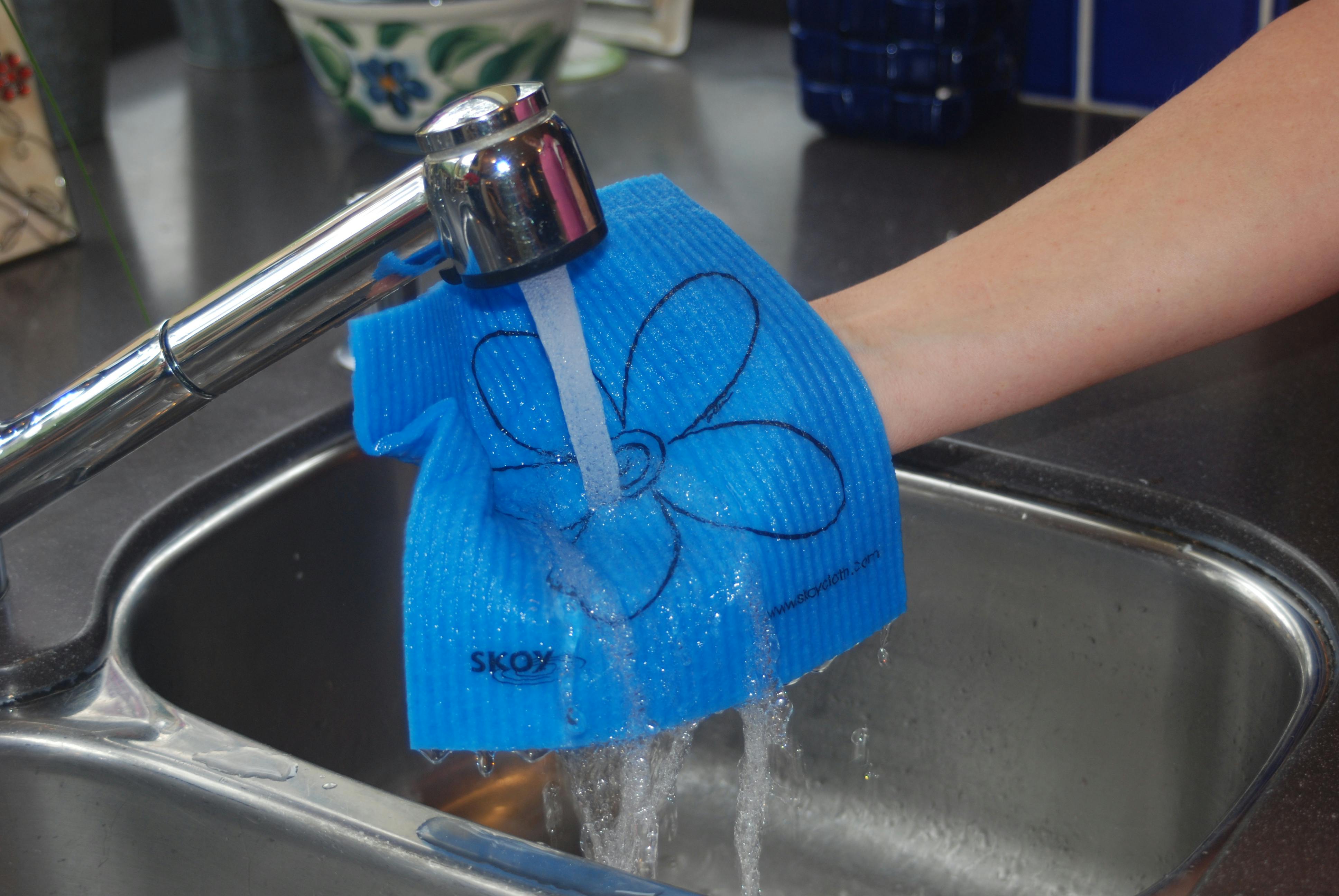 A Skoy reusable cloth, wet under a faucet.