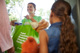 woman from instacart delivers groceries to door