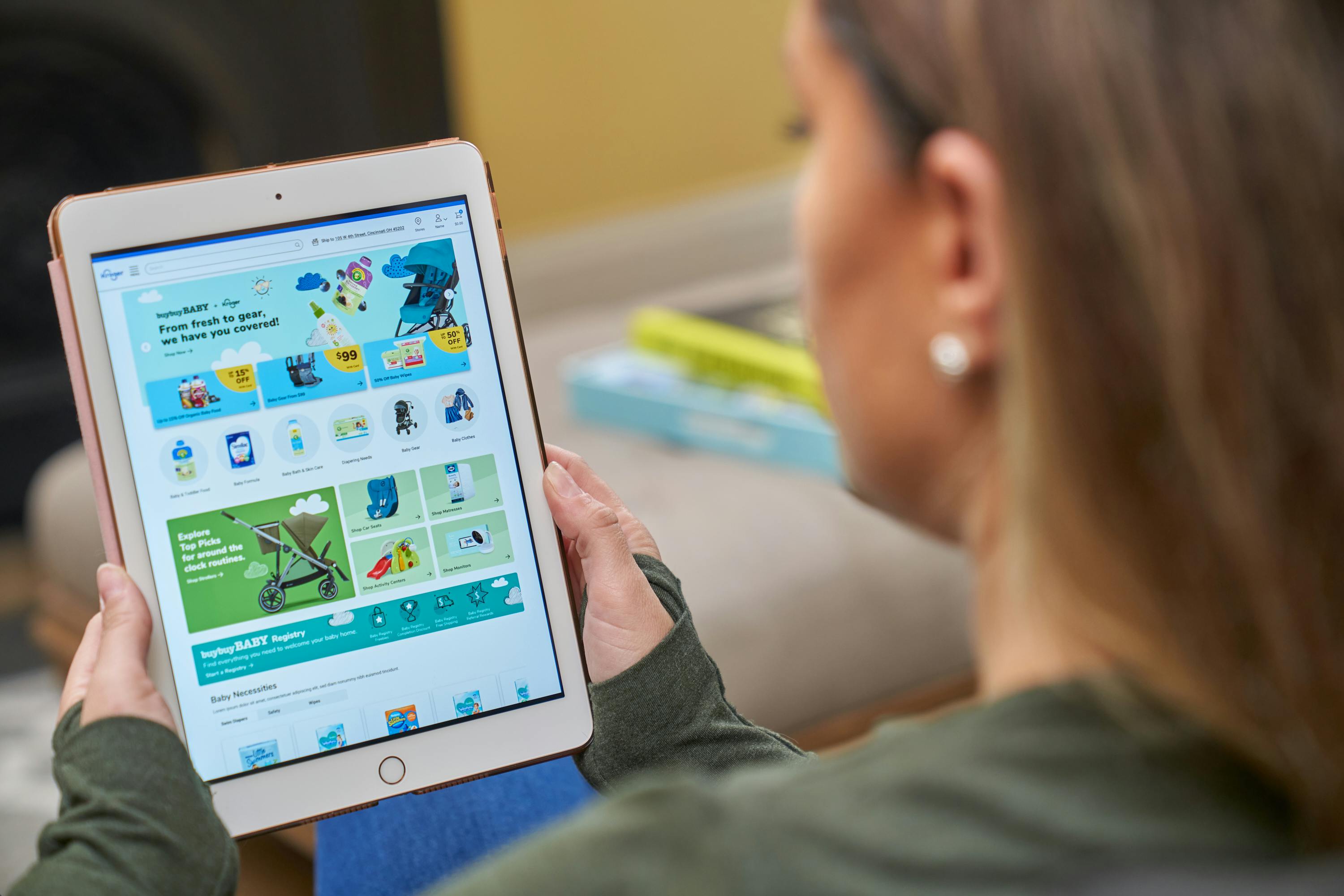 Woman looking at an iPad with the Kroger website's Bed Bath & Beyond storefront