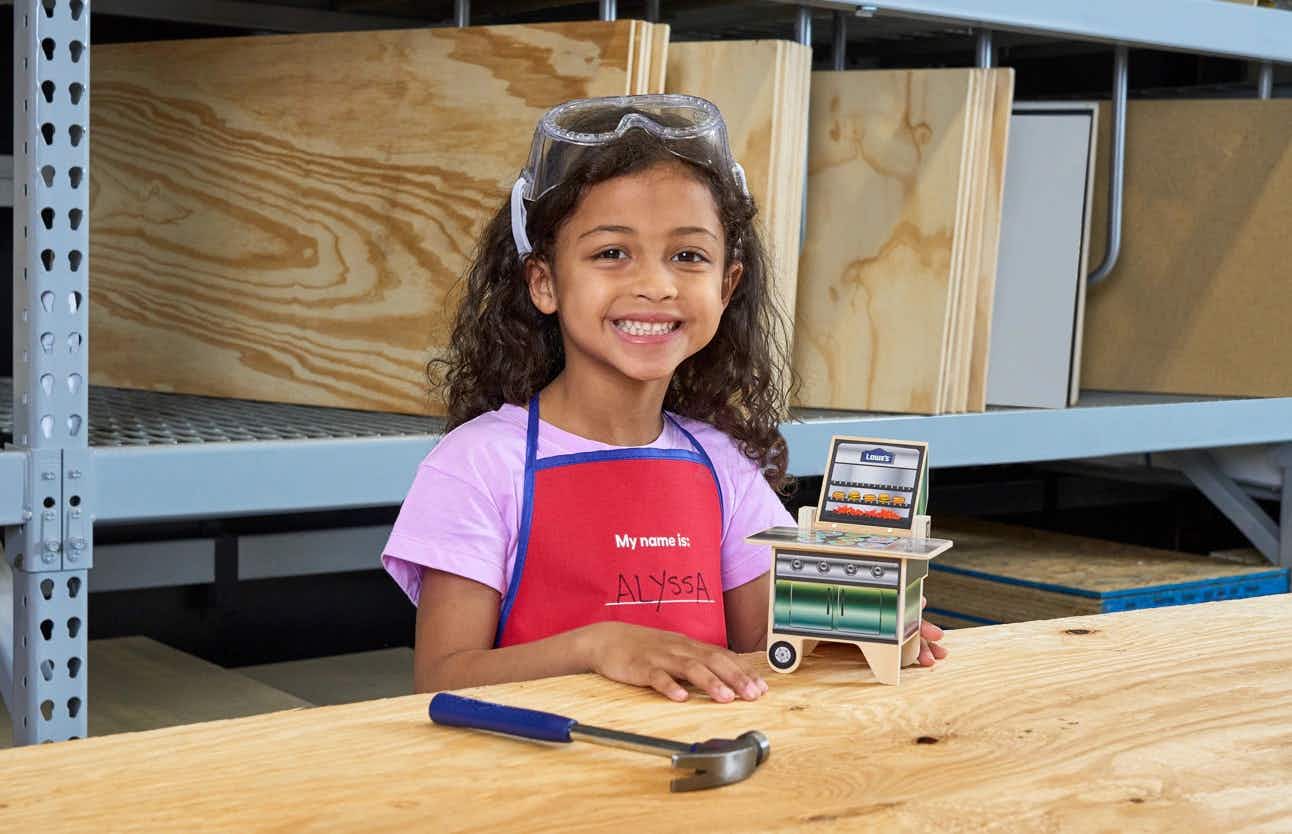 A child working on a Tic-Tac-Toe grill project at Lowe's Kids Workshop
