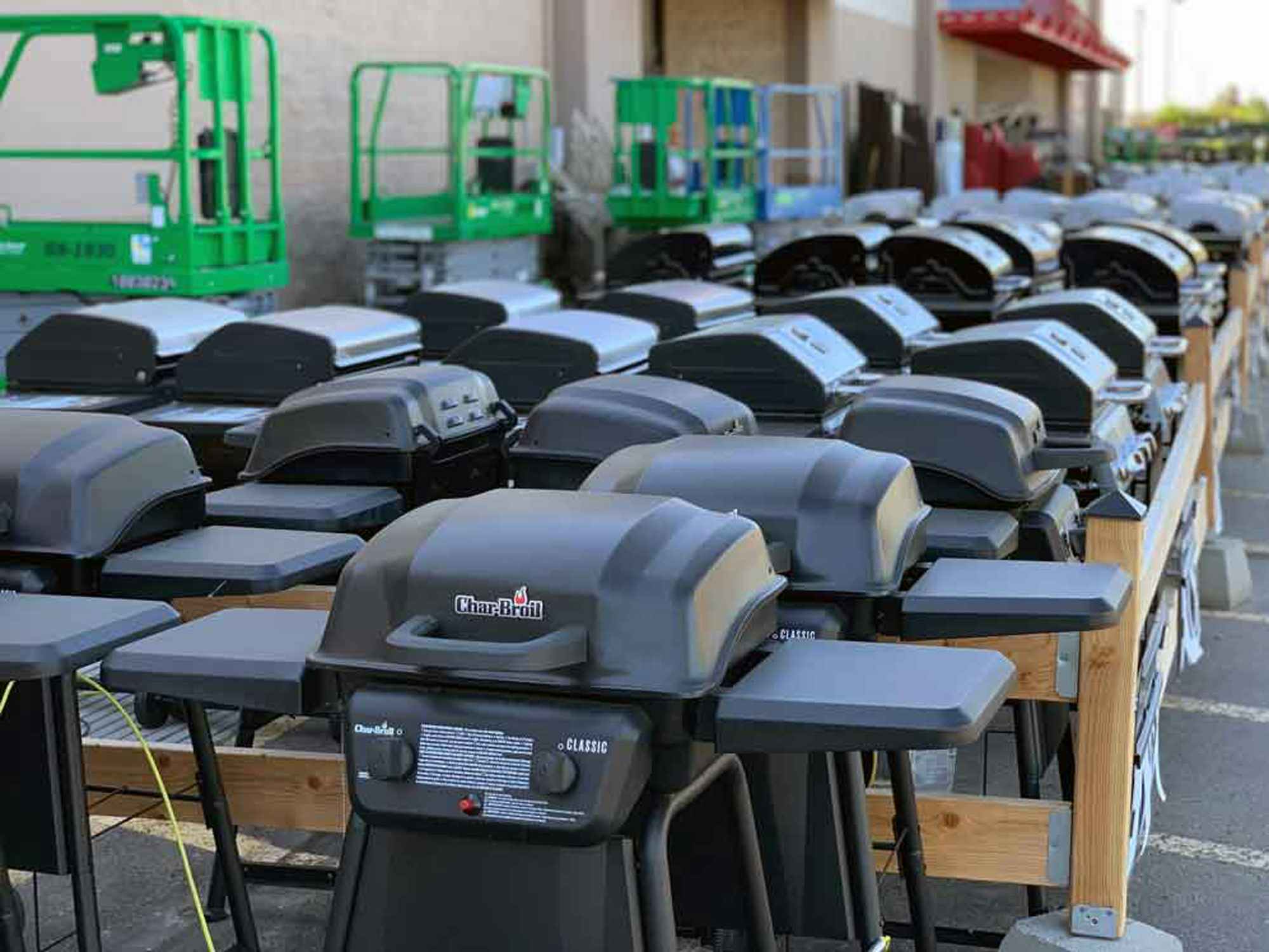 A bunch of grills lined up outside of Lowe's for their 4th of July sale