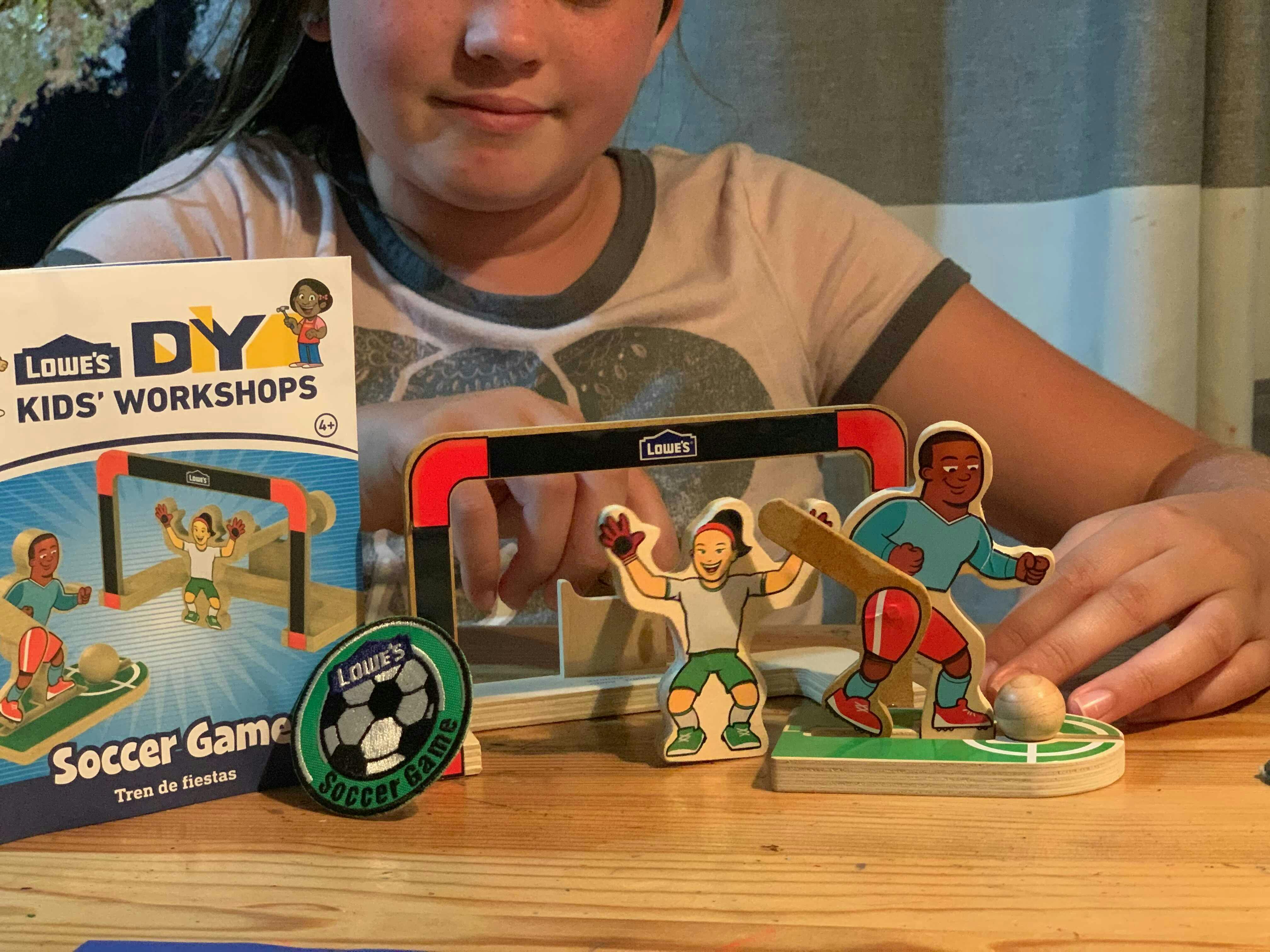 Lowes diy kids workshops soccer game set up on table with child playing with game