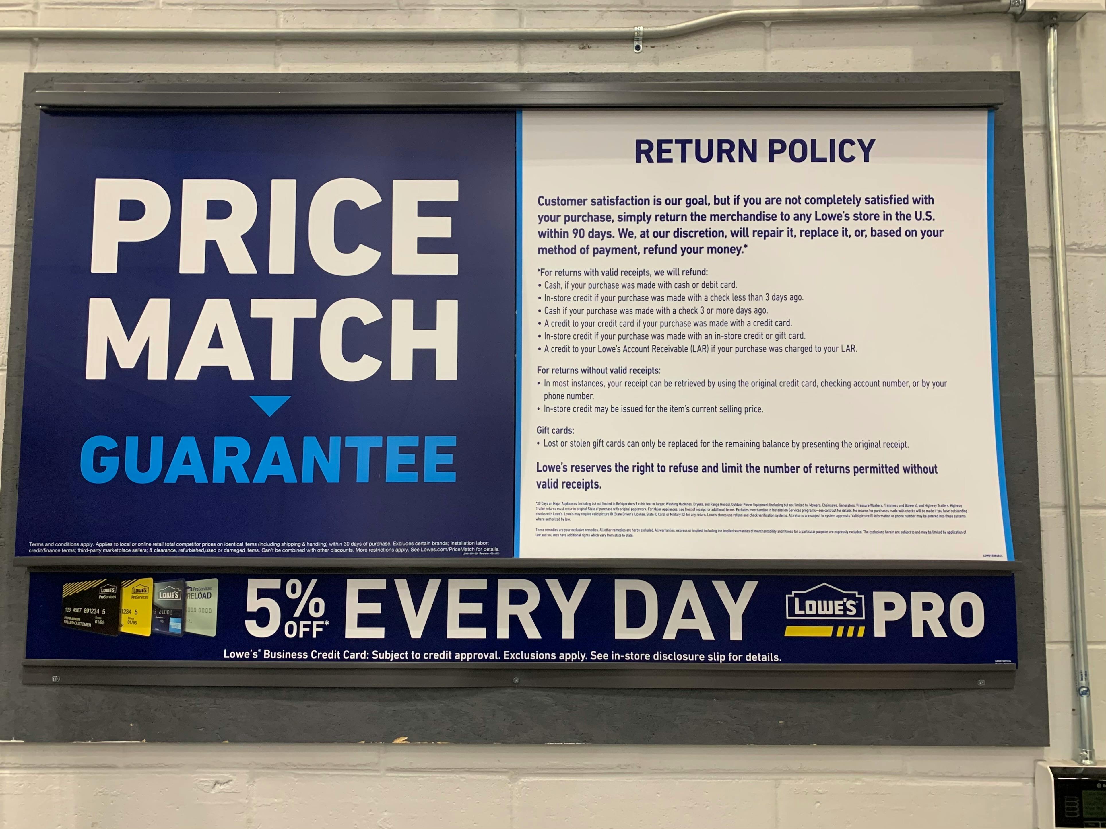 Sign of the Lowe's price match guarantee and return policy inside Lowe's.