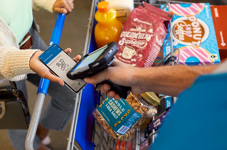 A Sam's Club Employee scanning a barcode on an customers phone to check them out with a scan and go order.
