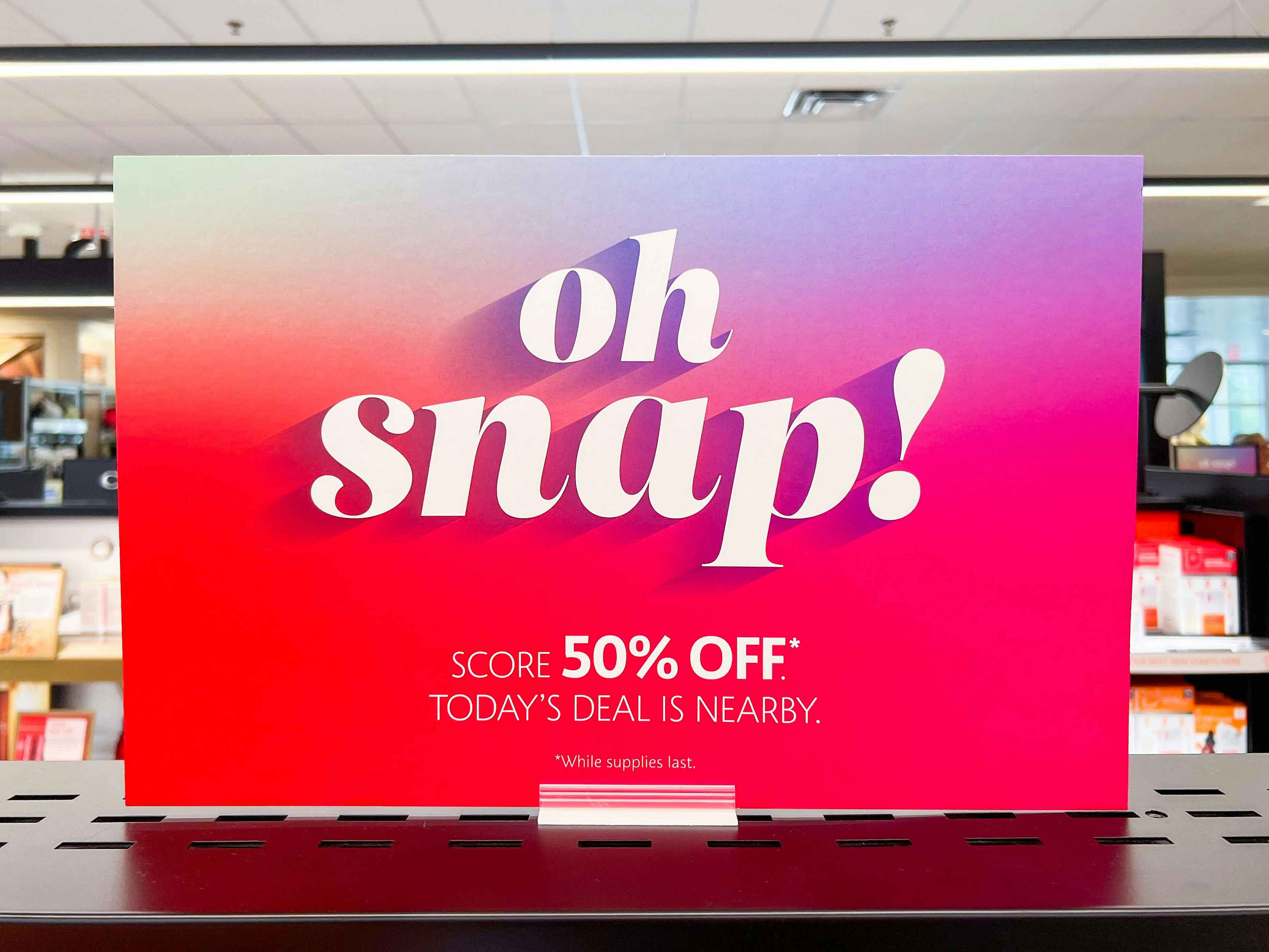 A sign for Sephora's Oh Snap sale attached to a shelf inside Sephora