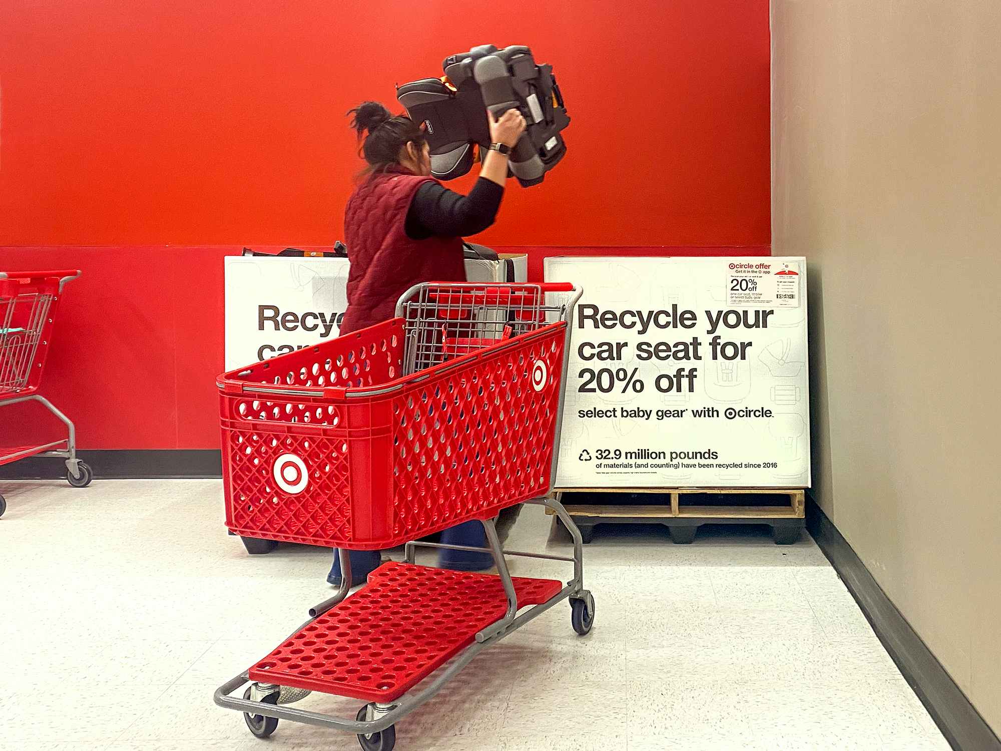 target employee placing car seats into box for trade-in event in store