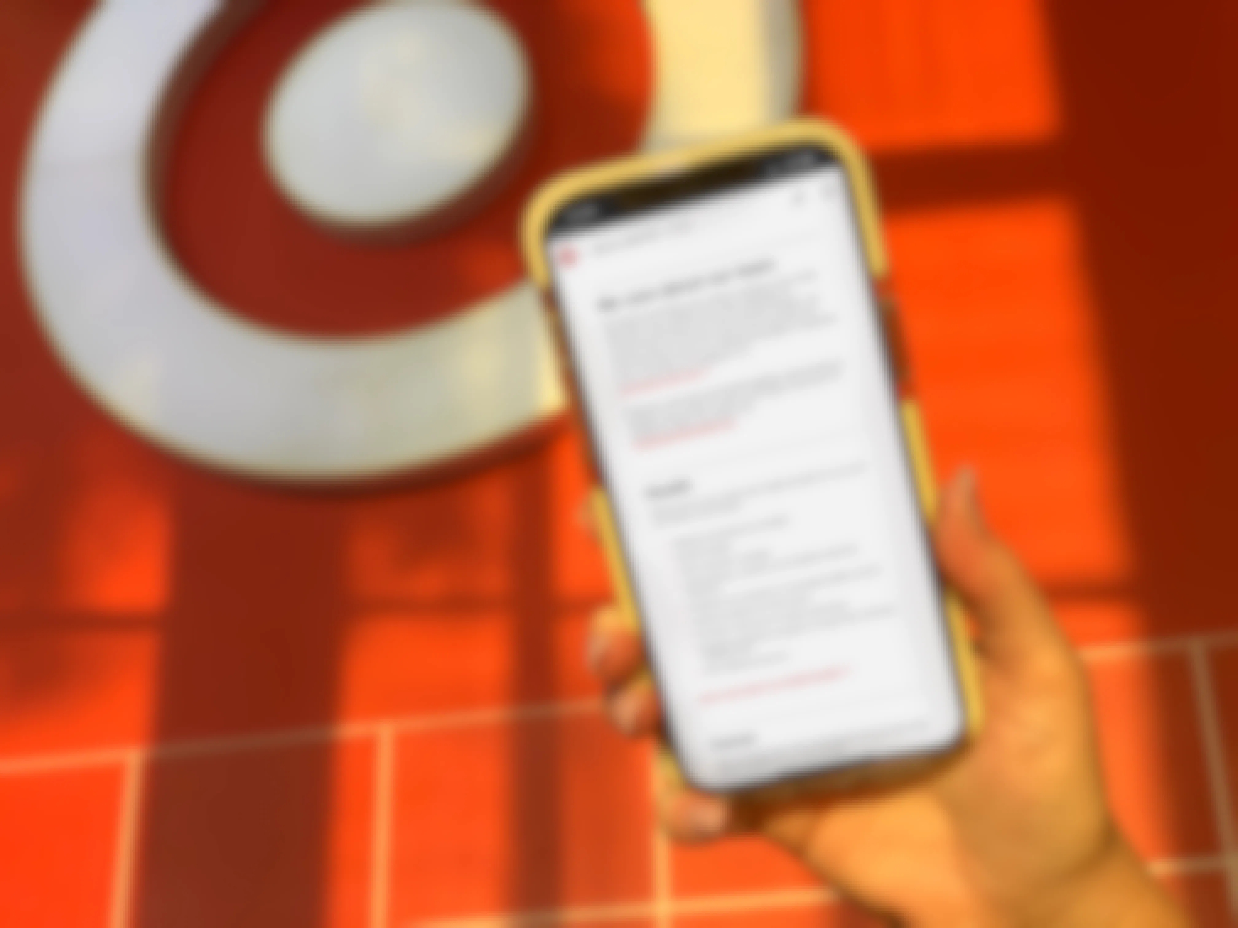 hand holding cellphone with target benefits on screen in front of target store sign