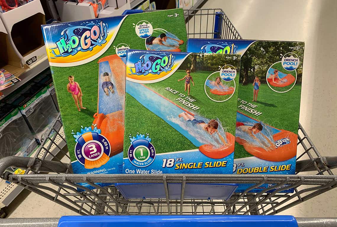 Three H2O Go lawn water slides in the basket of a Walmart shopping cart.