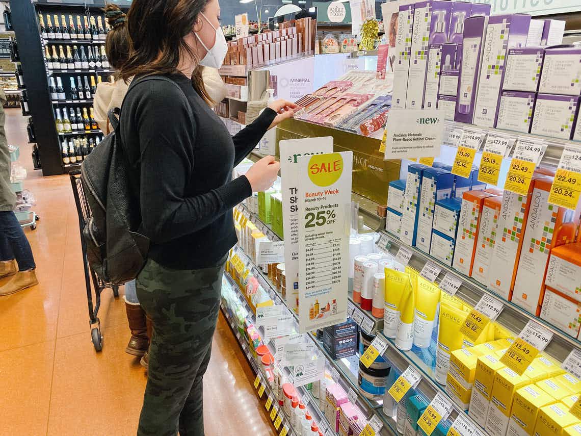 A woman looking at beauty products inside whole foods
