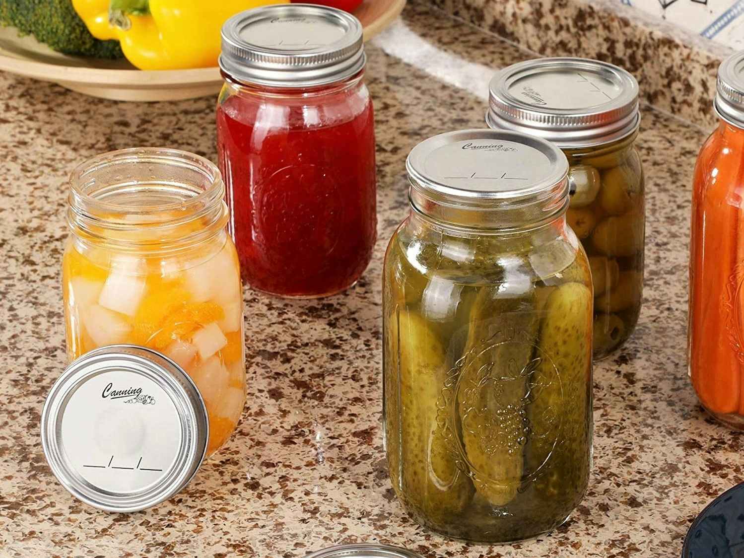 Several canning jars sitting on a counter with different food items sealed inside.