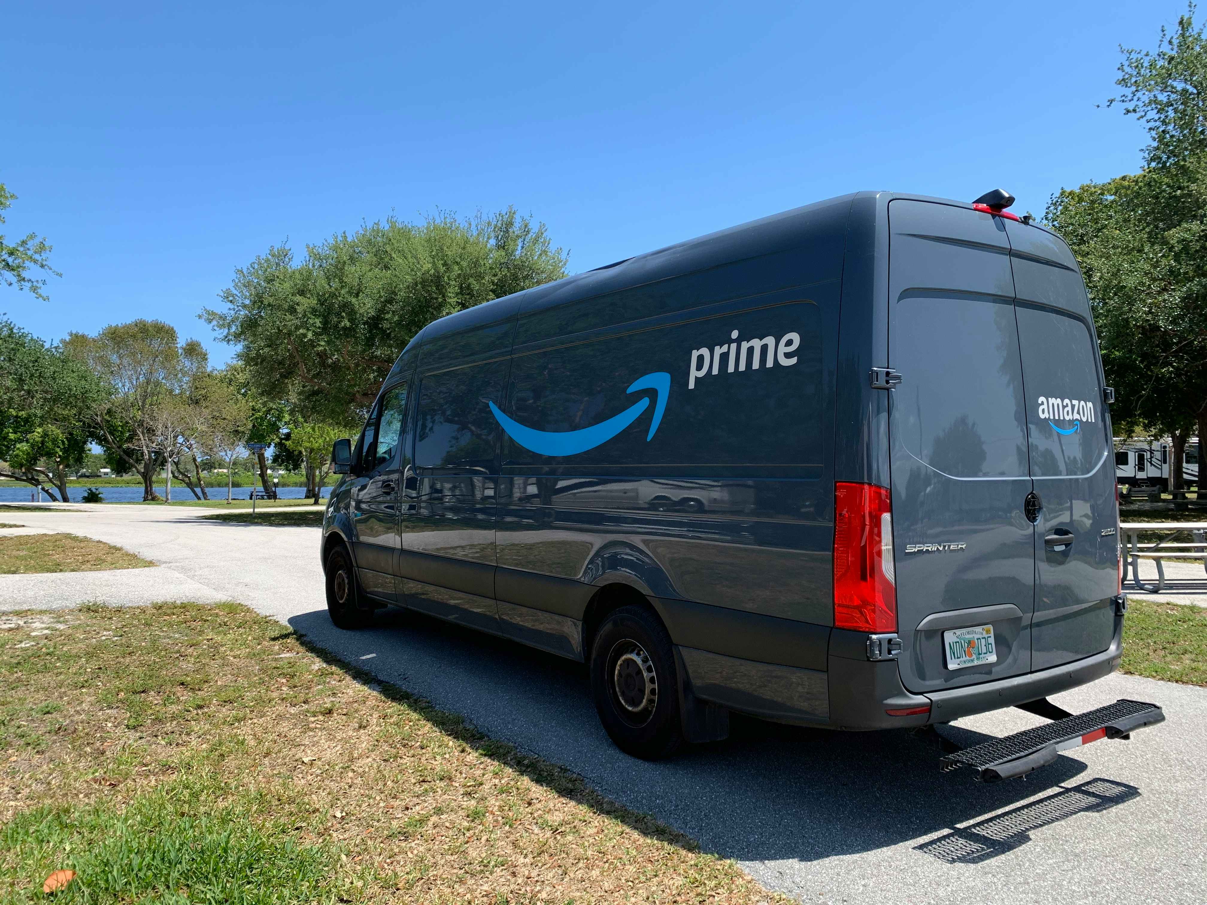 An Amazon delivery van parked in a driveway.