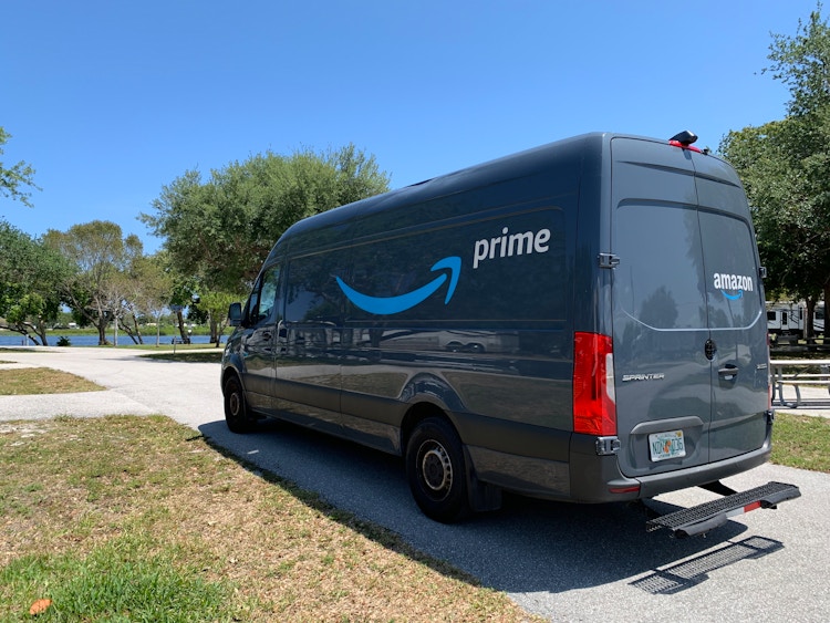 An Amazon delivery van parked in a driveway.