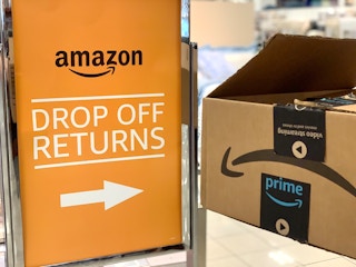 amazon boxes in front of amazon drop off sign in store