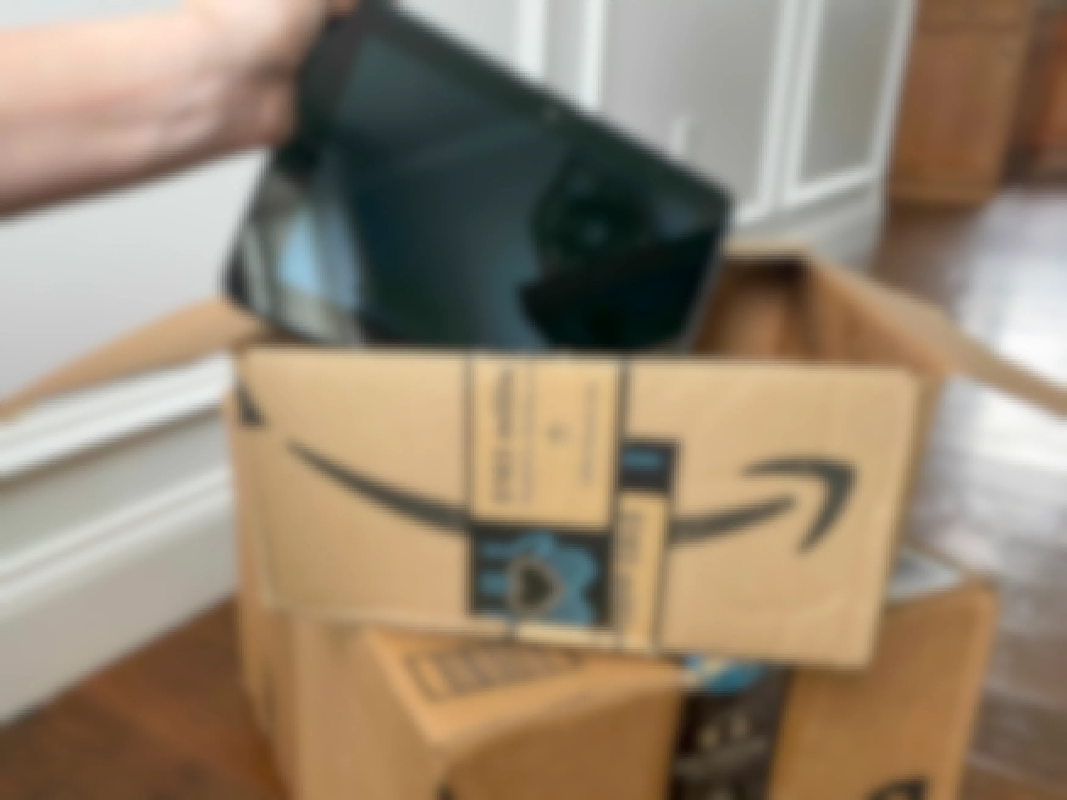 An amazon fire tablet held over an amazon box