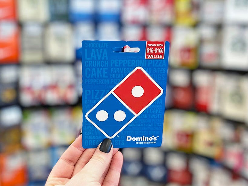 Someone holding up a Domino's gift card