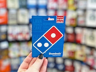 Someone holding up a Domino's gift card