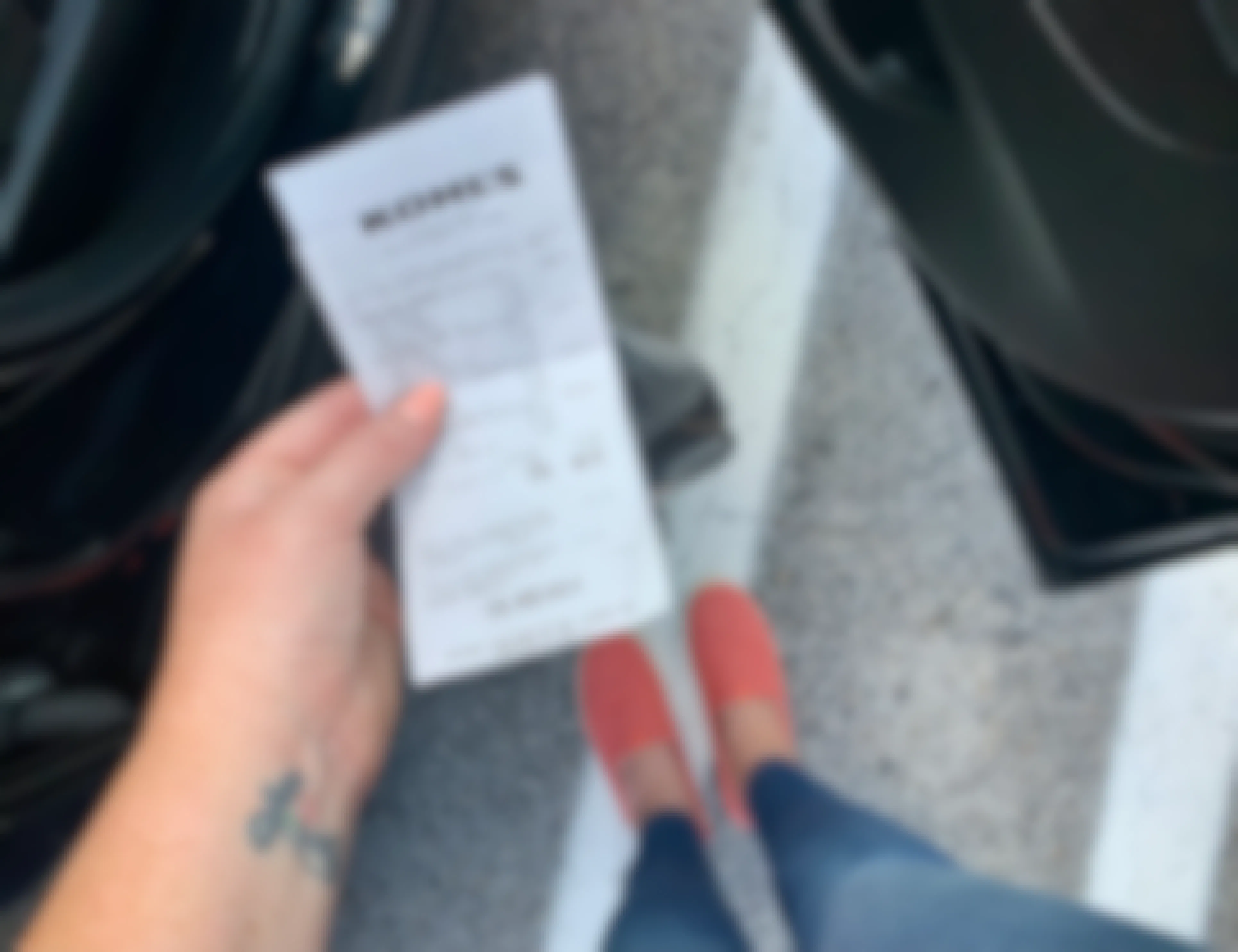hand holding receipt while about to get in car