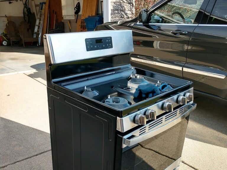 an old oven on the driveway in front of someone's garage