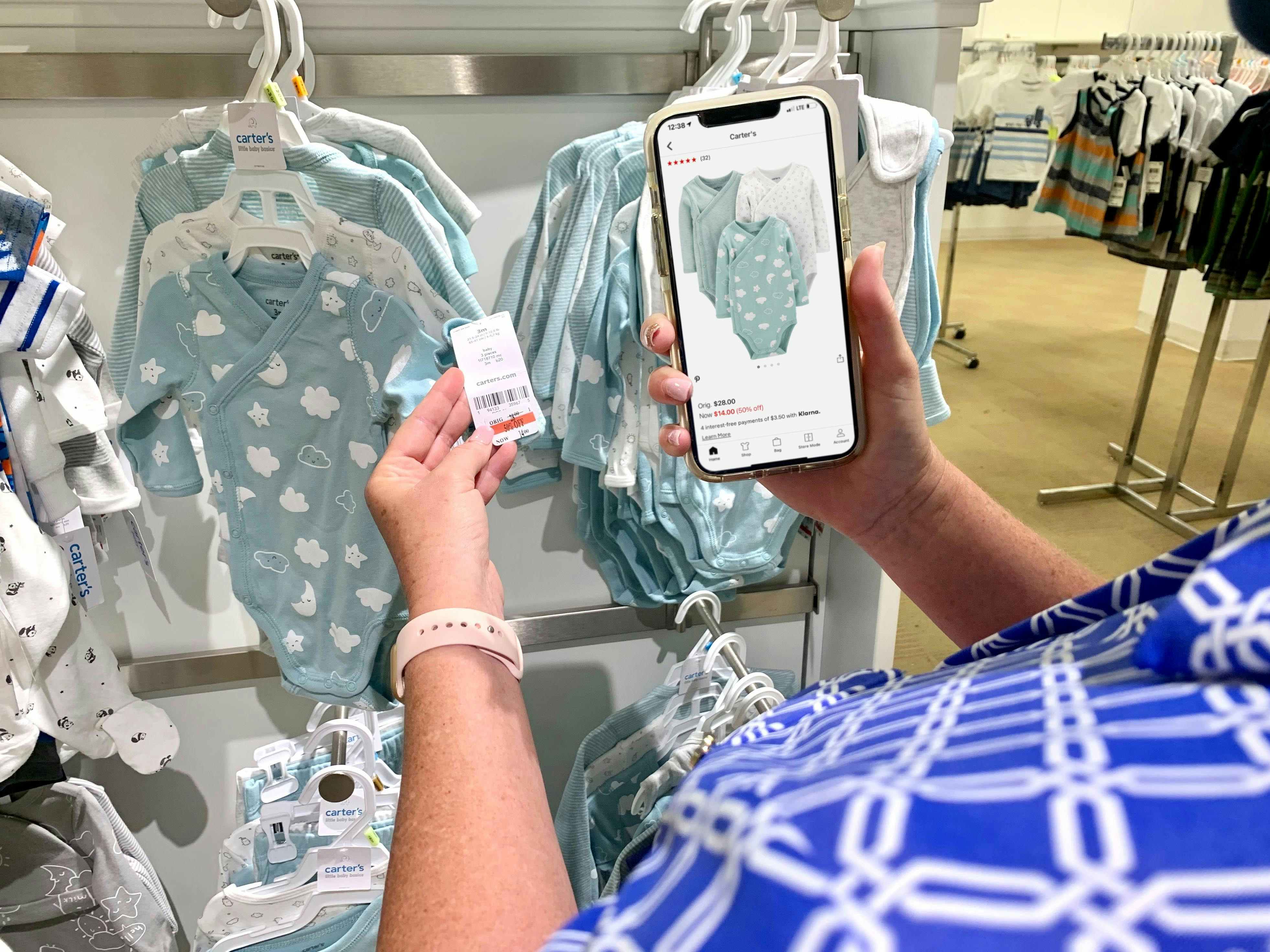 cwoamn comparing price on app and on baby clothes on rack 