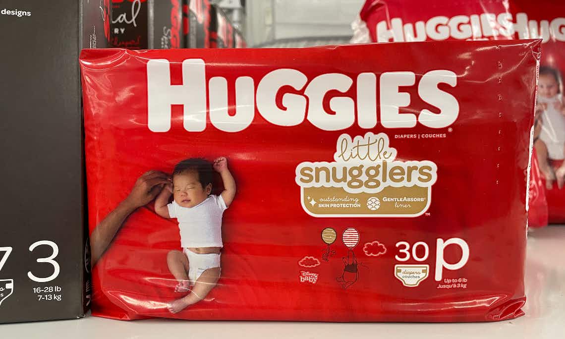 A bag of Huggies diapers sitting on the floor.
