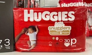 A bag of Huggies diapers sitting on the floor.