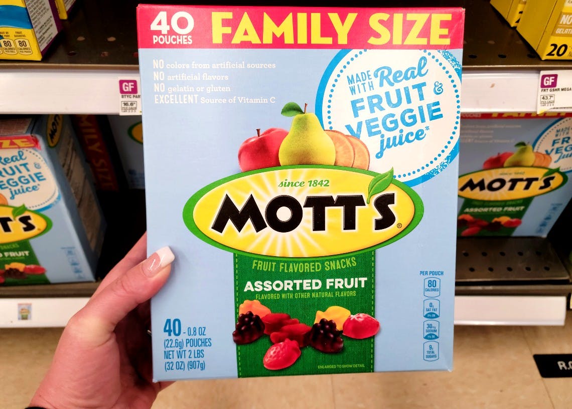 Hand holding a Mott's family size fruit snack box of 40 pouches.