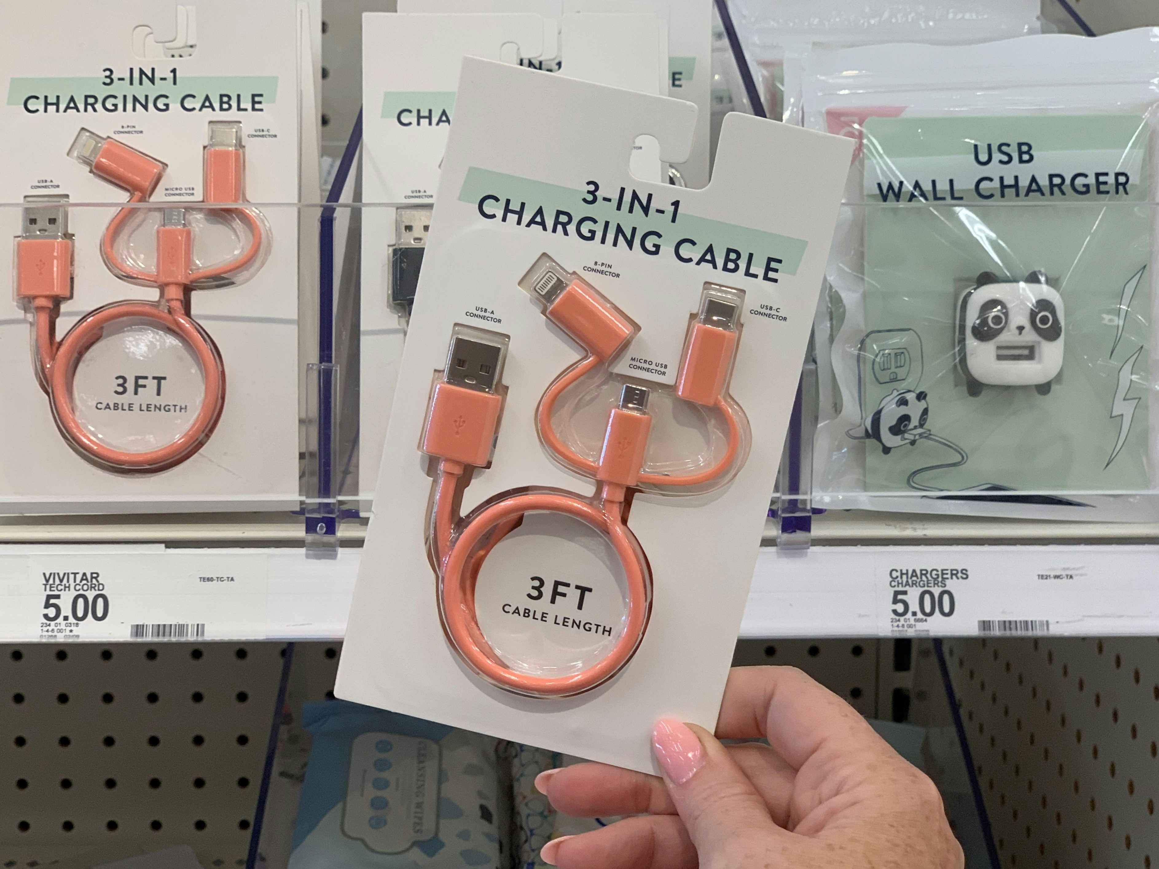 hand holding charging cables in front of shelf