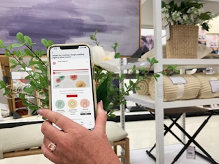 hand holding cellphone with target regisrty app in home decor section of store