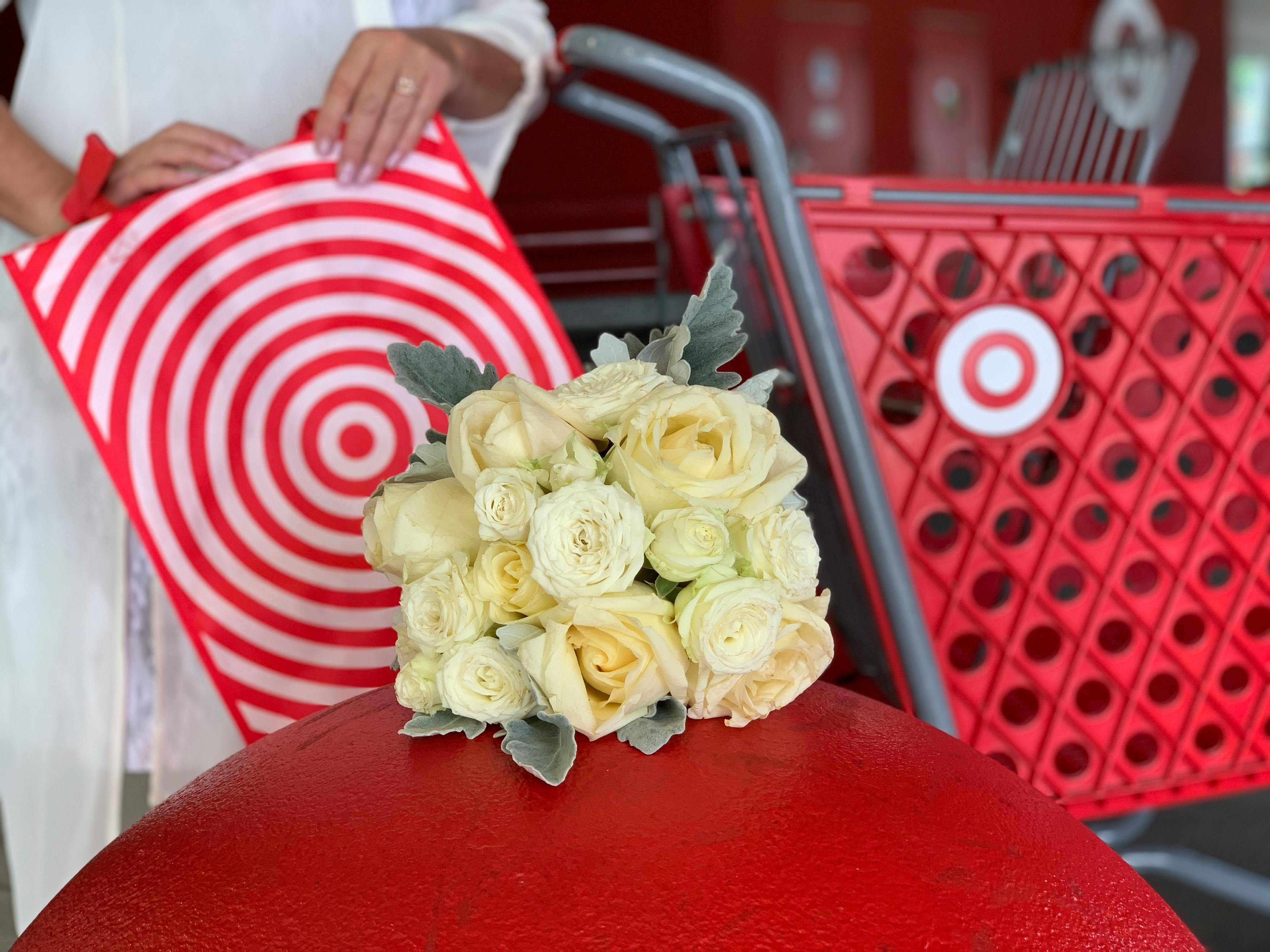 white bridal bouquet on big red ball near close up of target bag and shopping cart