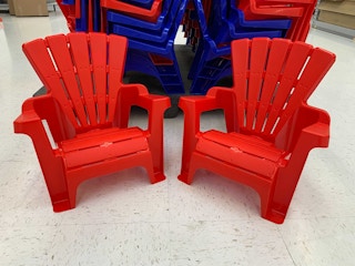 red plastic kids adirondack chairs on the floor of walmart