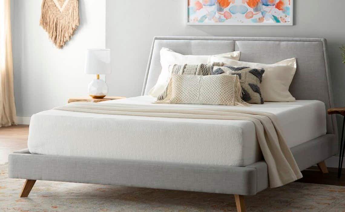 mid-century bed with mattress, throw, and pillows