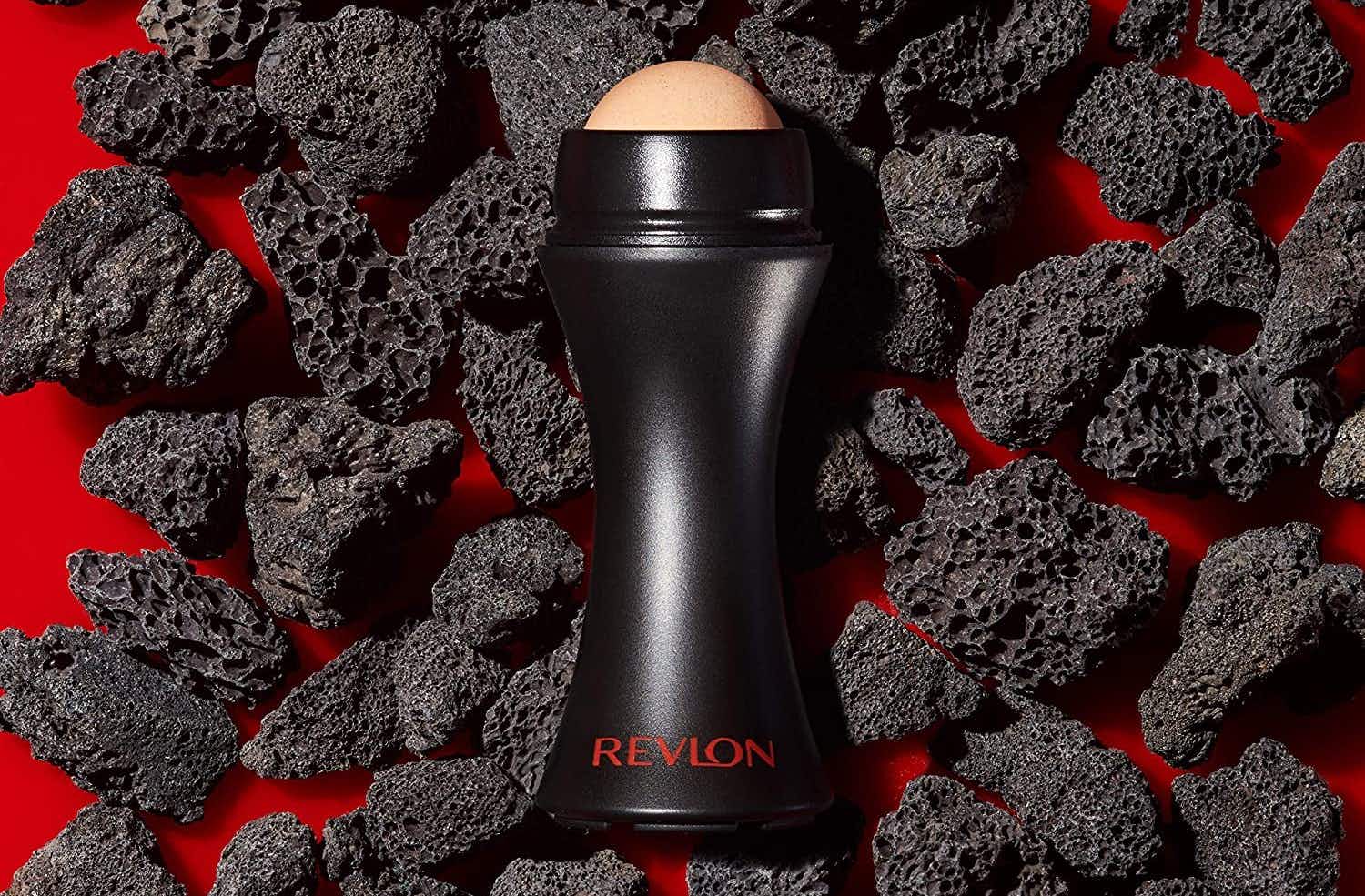 A Revlon volcanic face roller laid on top of volcanic rocks
