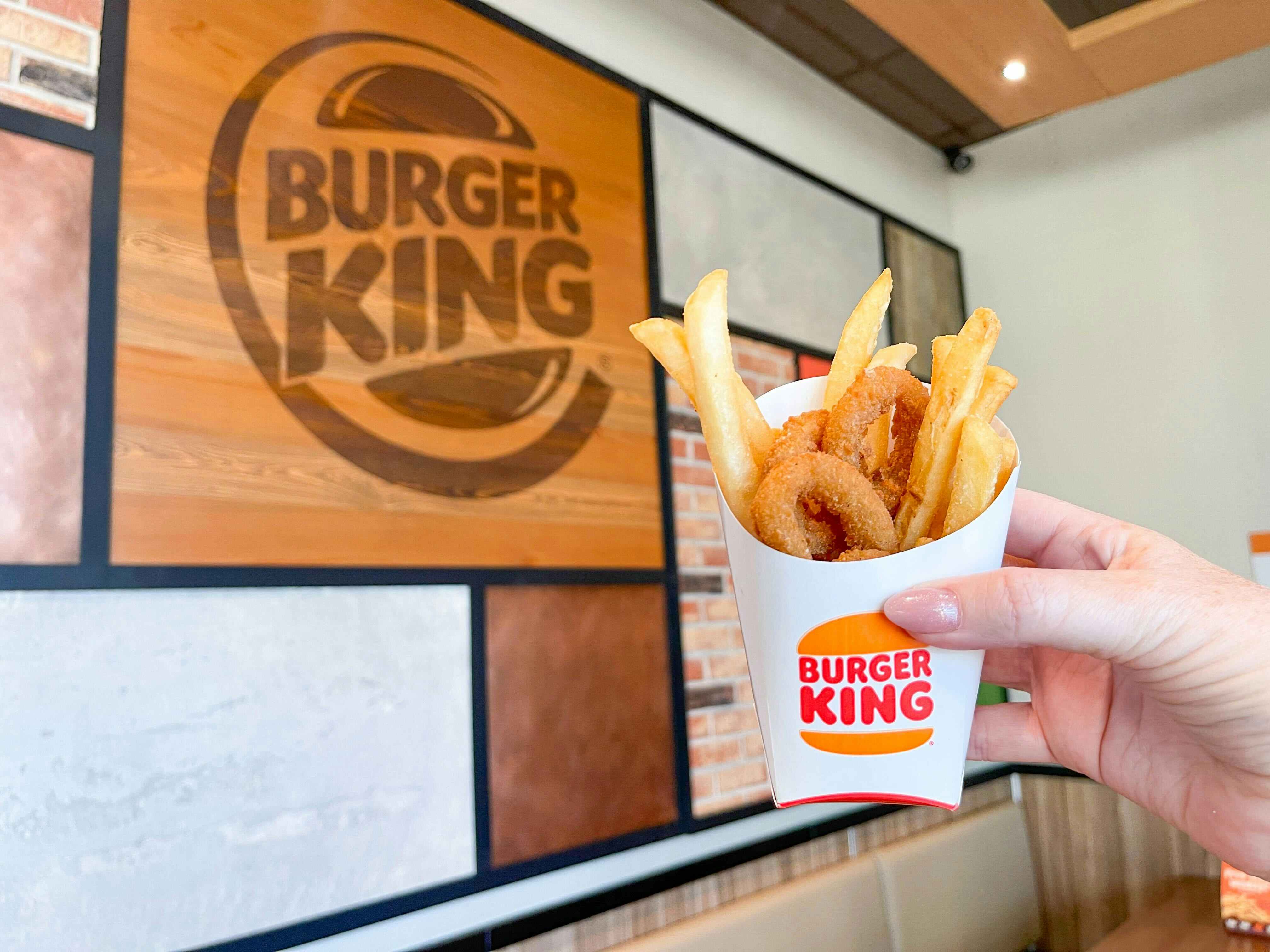 burger king frings a mix of fries and onion rings being held up inside burger king