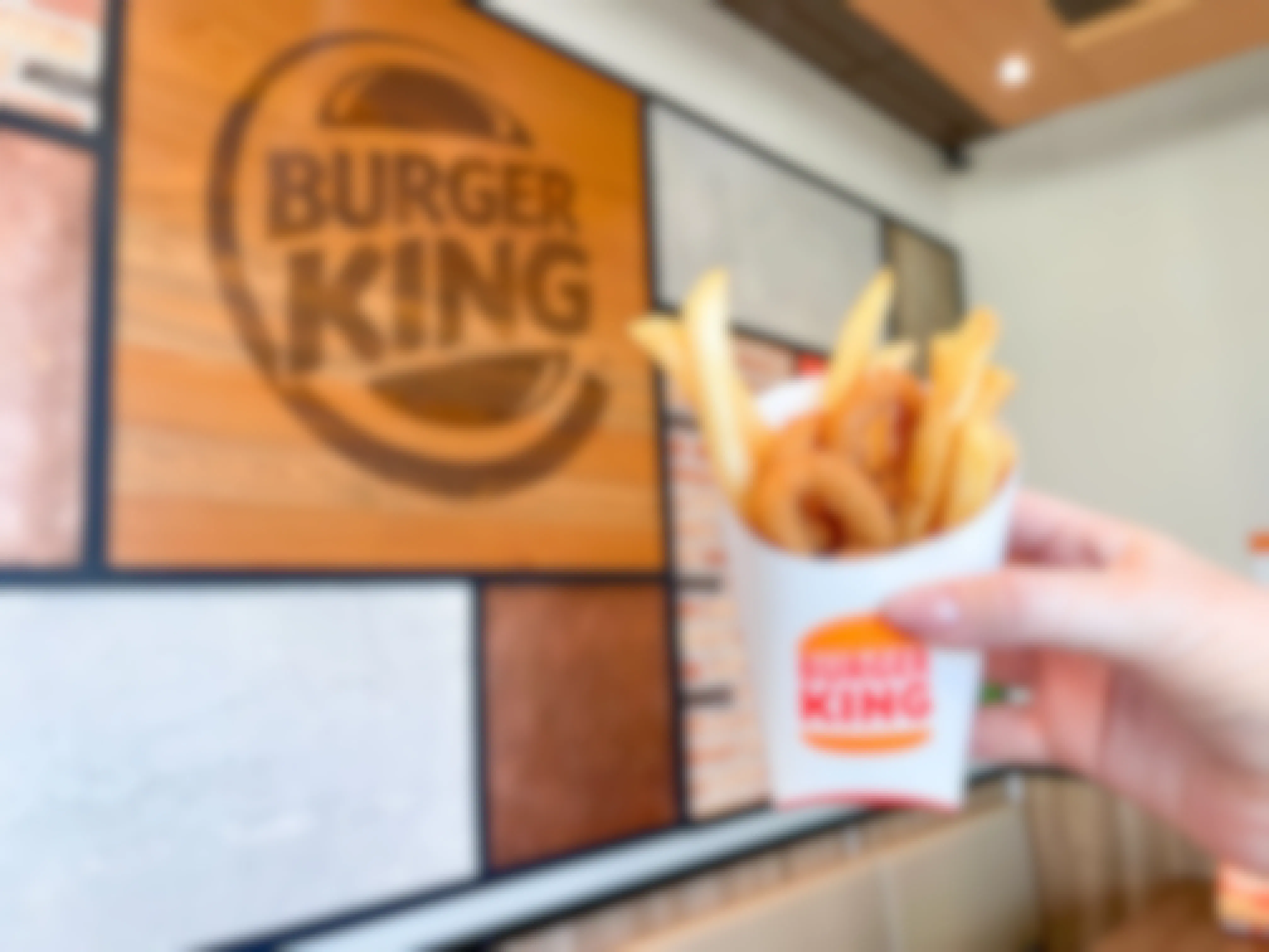 burger king frings a mix of fries and onion rings being held up inside burger king