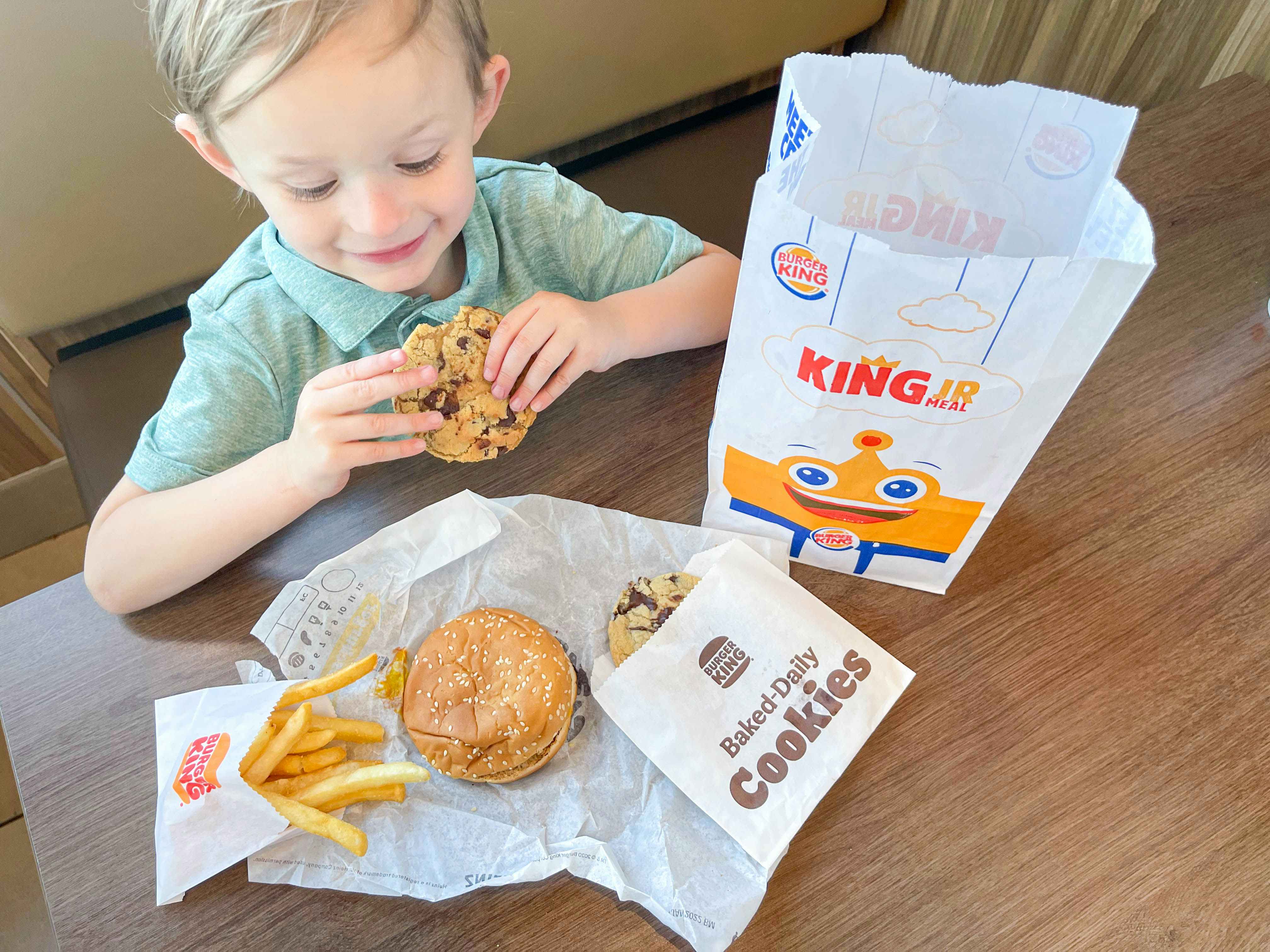 a boy eating a coffee at burger king with kids meal