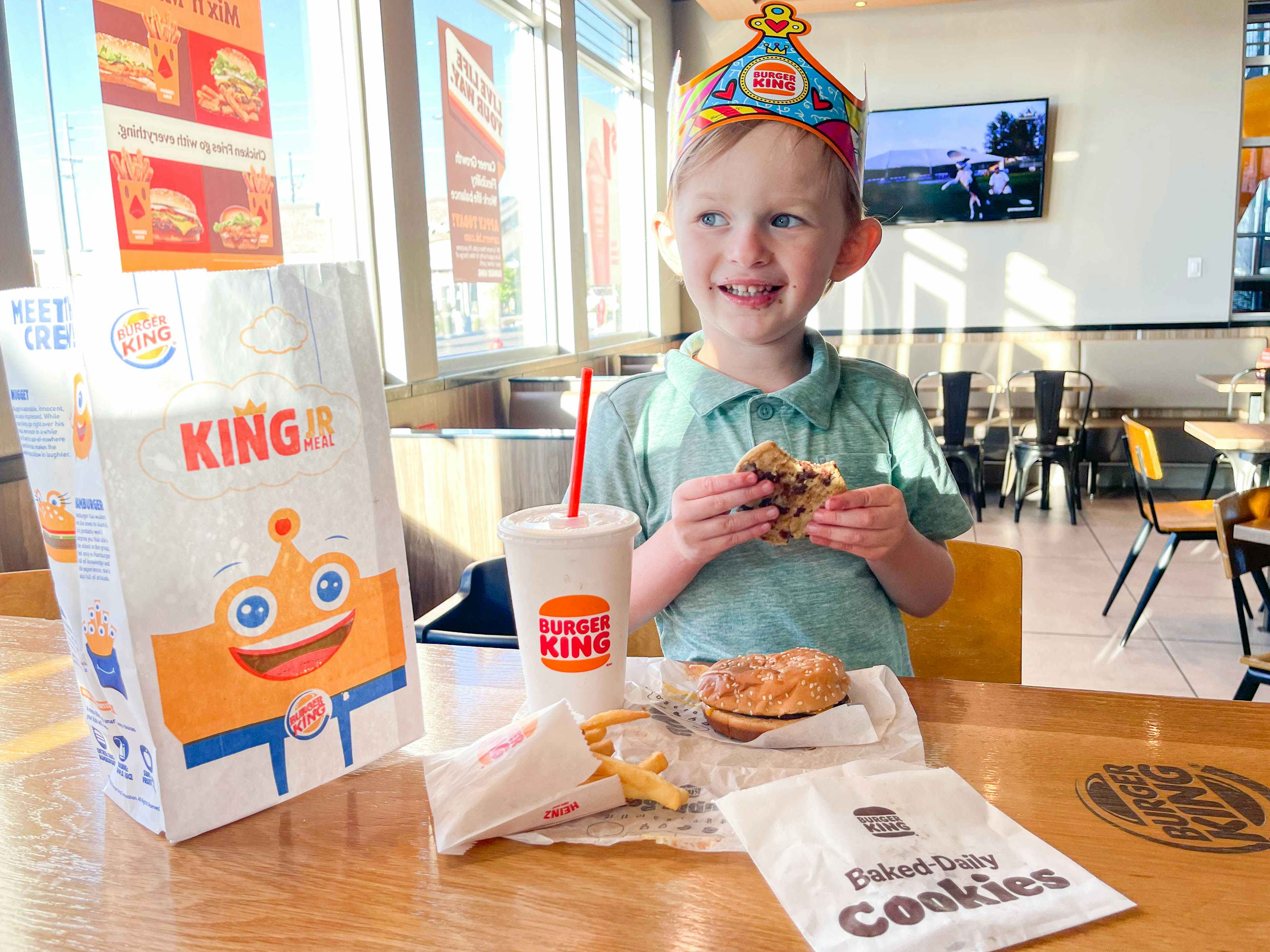 a boy eating a coffee at burger king with kids meal