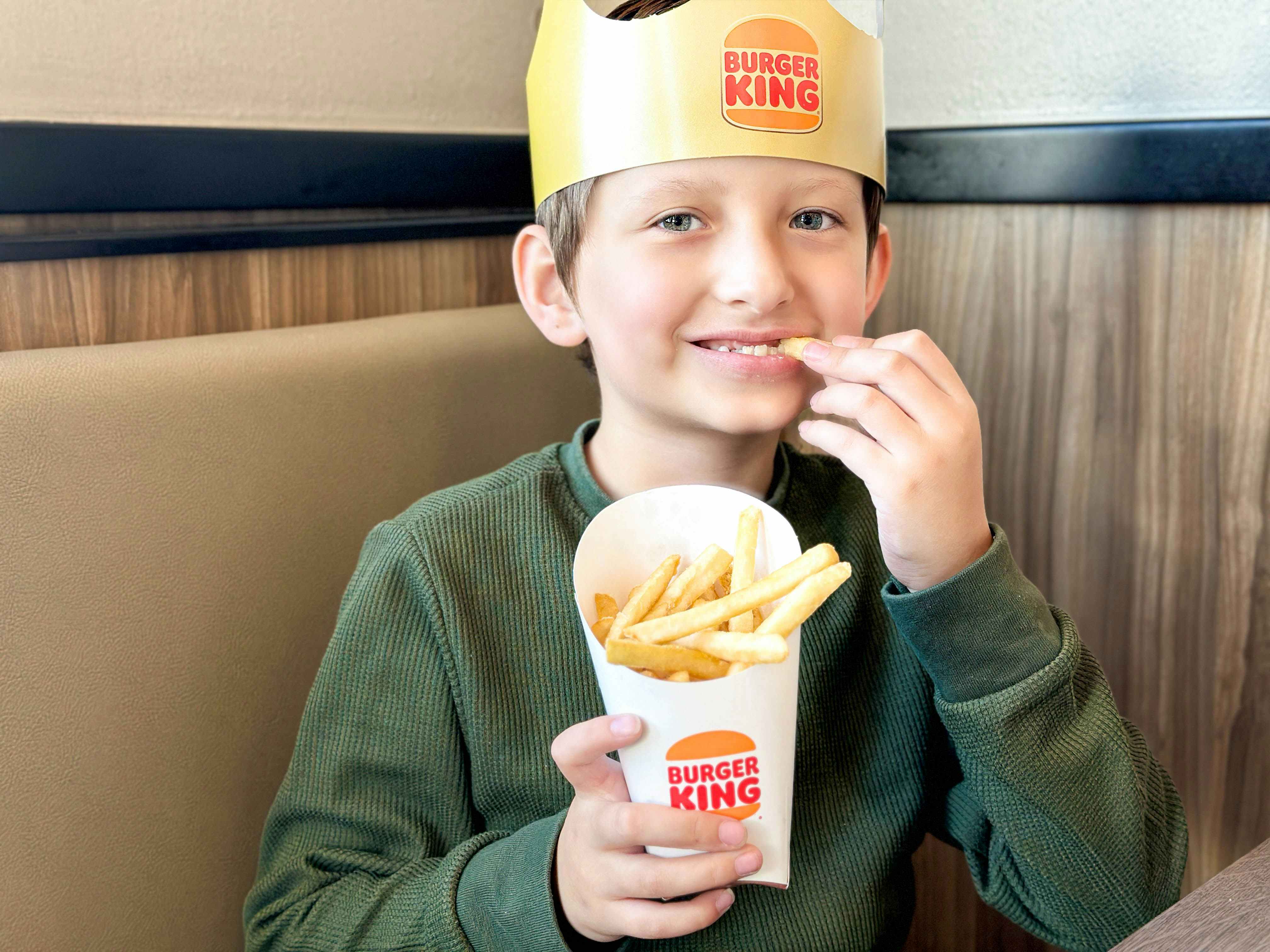a boy eating burger king fries 