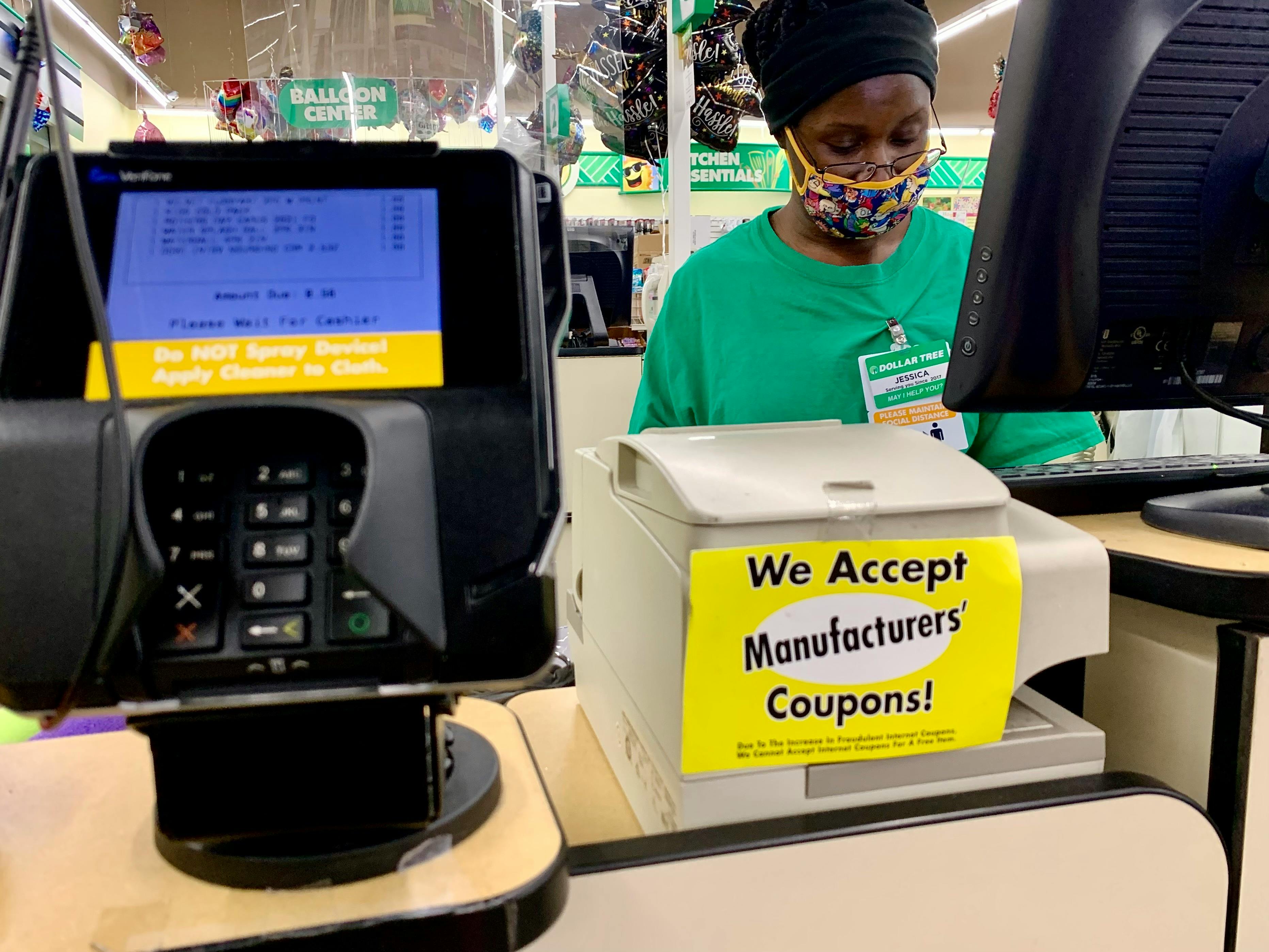 check-out lane at dollar tree with manufacturers coupon acceptance sign