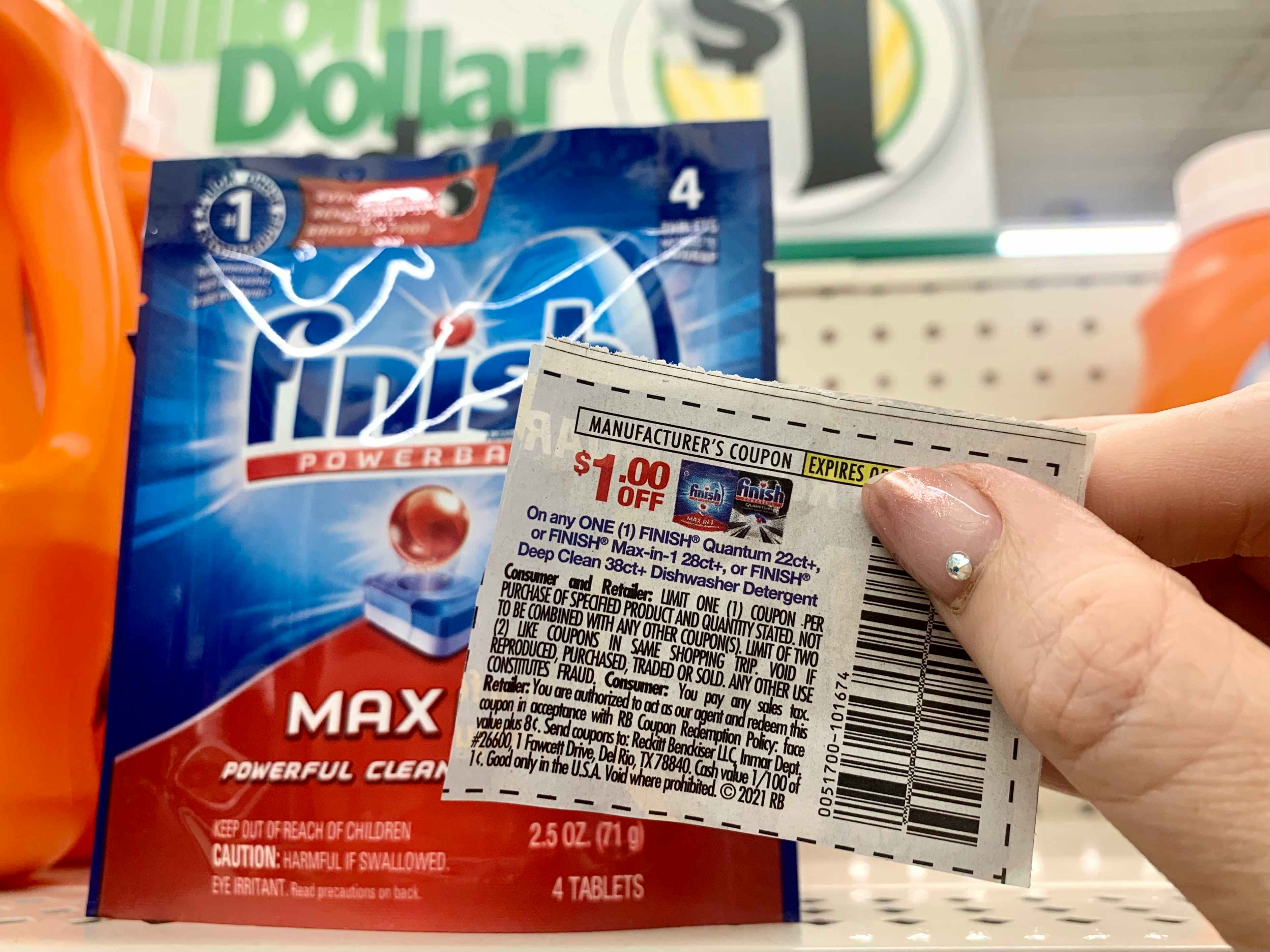coupon being held in front of finish max dishwashing pods