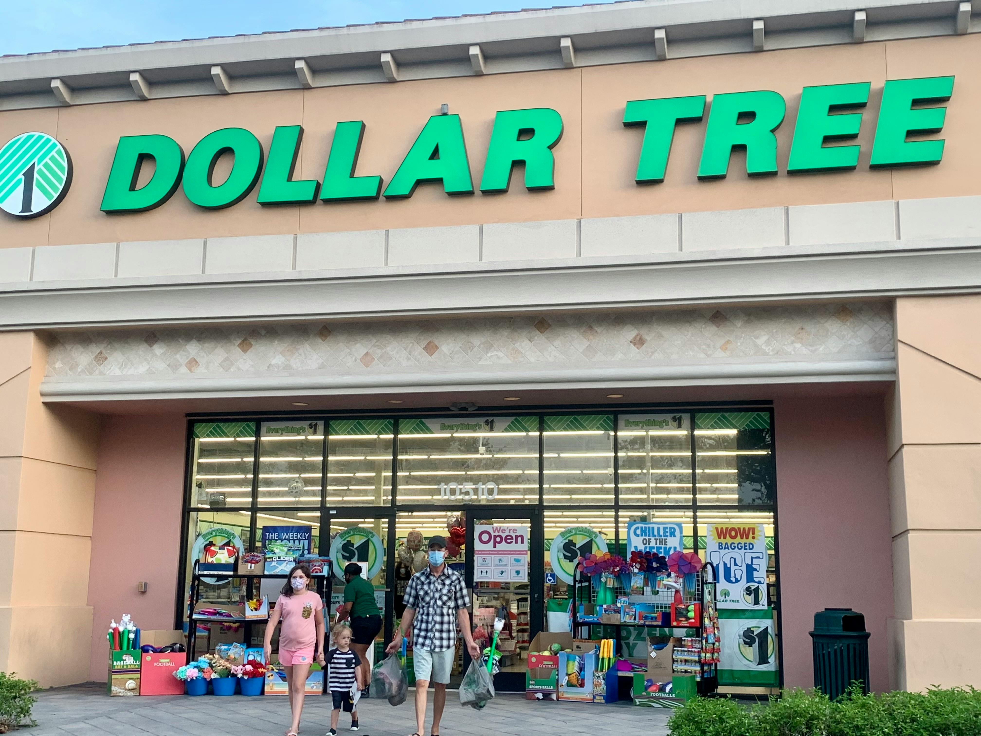 A family walking out of a Dollar Tree store.